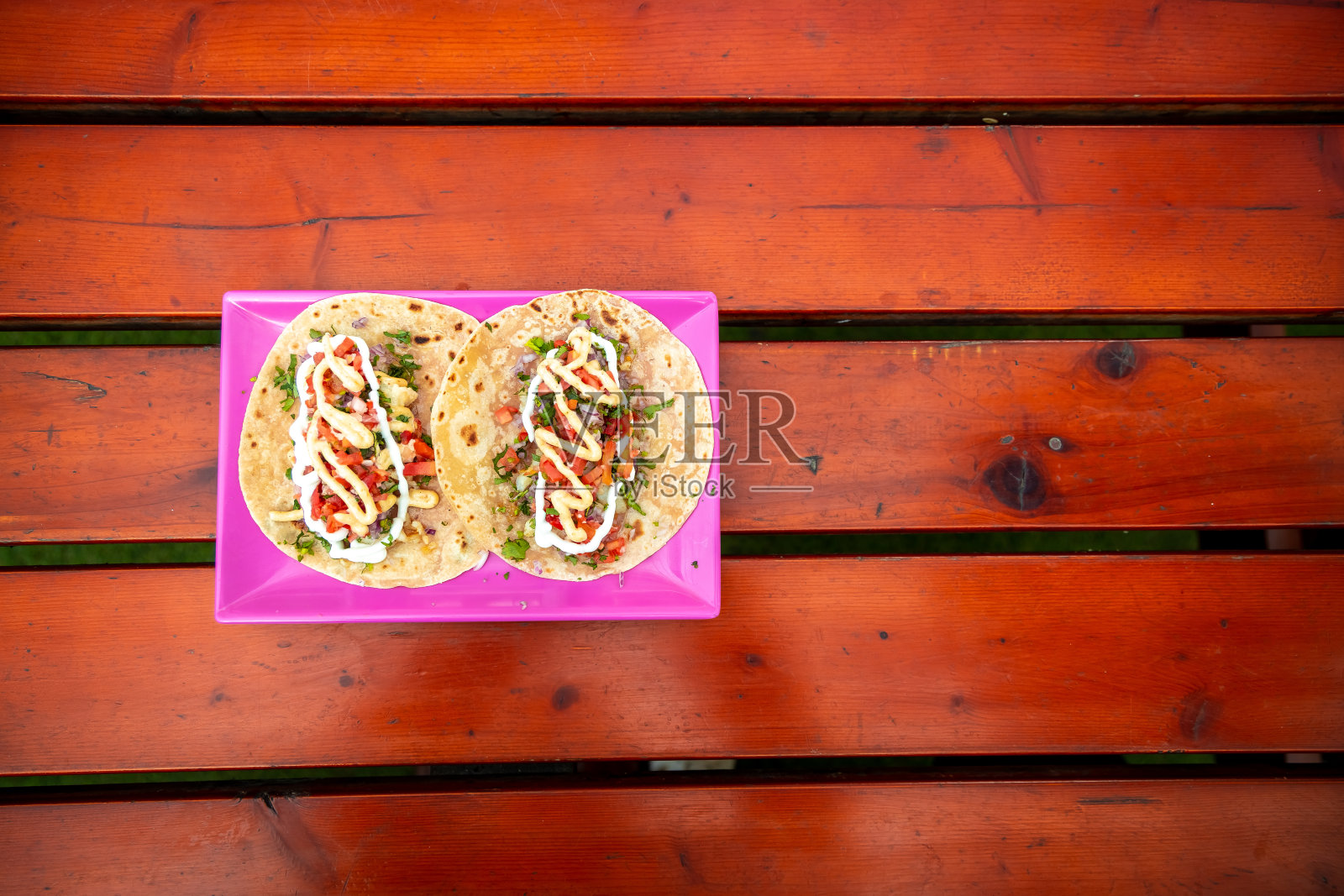 炸玉米饼。手工制作的墨西哥食物盛在一个粉红色的盘子里，放在一个木制的表面上。正宗的辣的食物。照片摄影图片