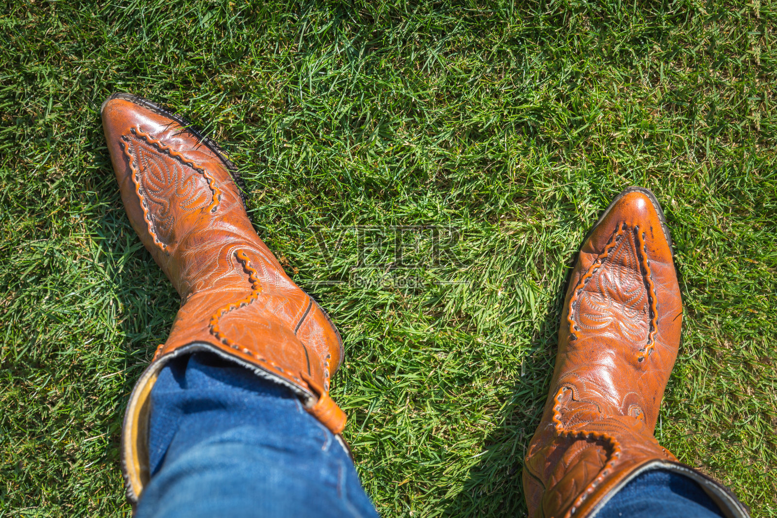穿着牛仔裤和牛仔靴的人，从上面看照片摄影图片