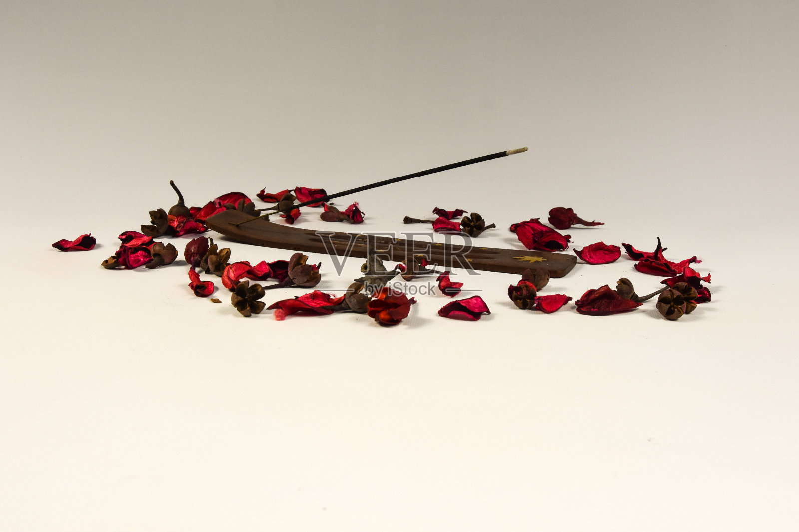 在白色的背景上燃烧香和覆盆子花瓣照片摄影图片