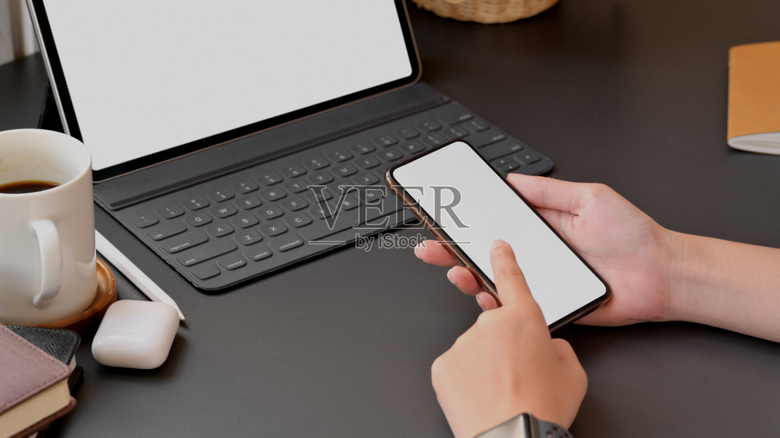 女子在黑色桌面上触摸智能手机空白屏幕的局部照片照片摄影图片