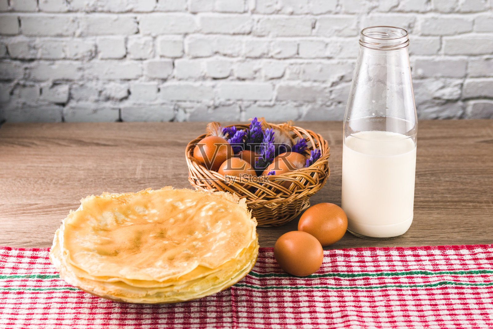 健康甜蜜的早餐。美味的传统薄煎饼，由米粉和一杯牛奶放在木桌上照片摄影图片