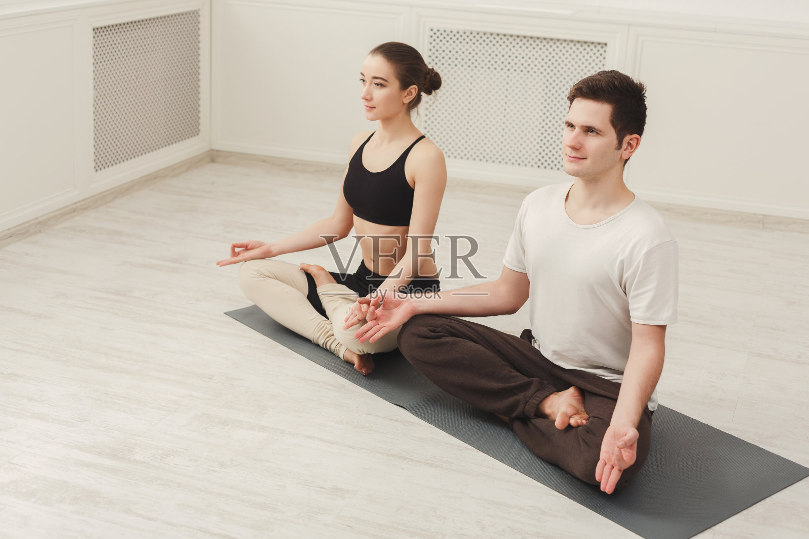 一对年轻夫妇在工作室一起冥想照片摄影图片