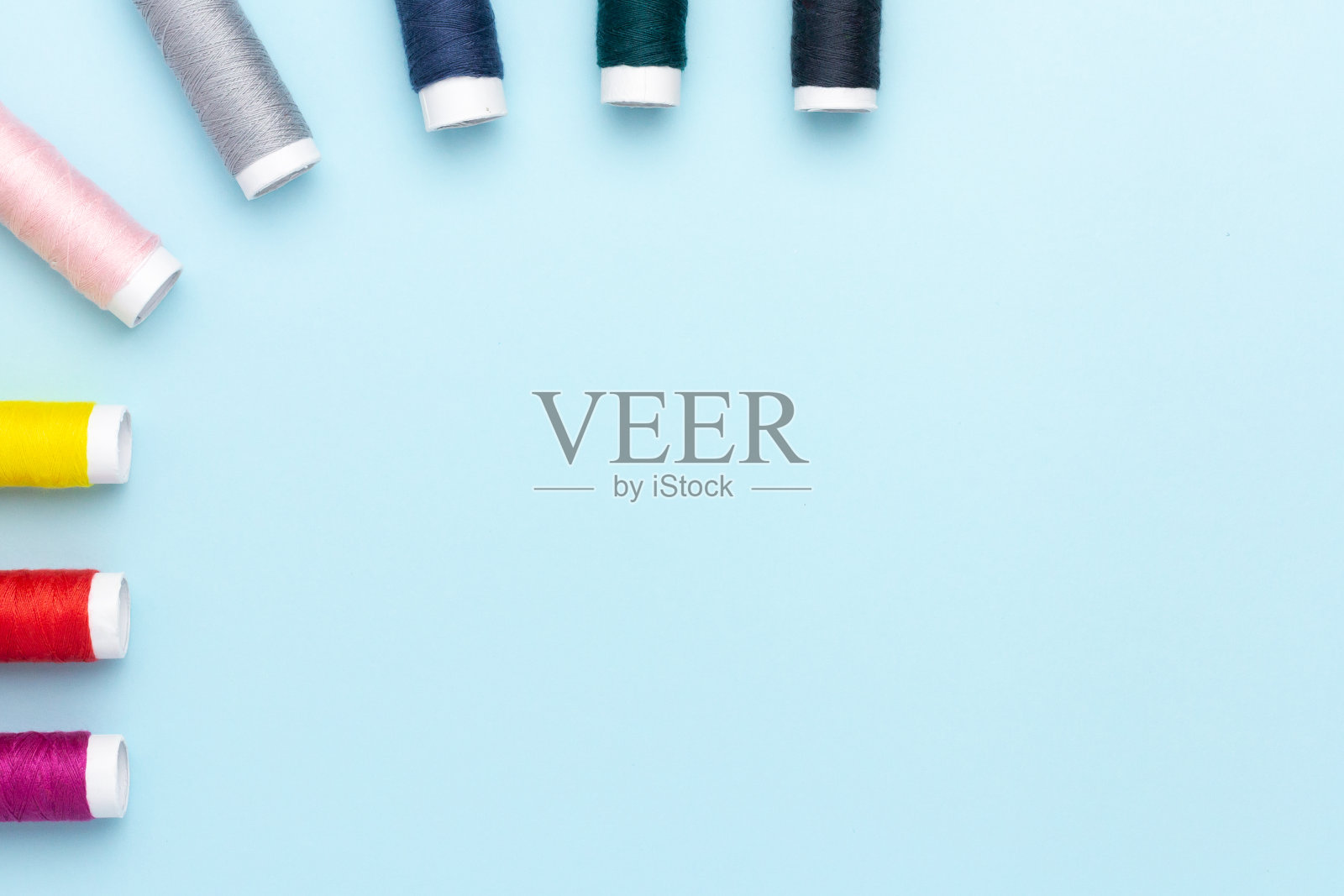 蓝色背景上的彩色缝纫线照片摄影图片