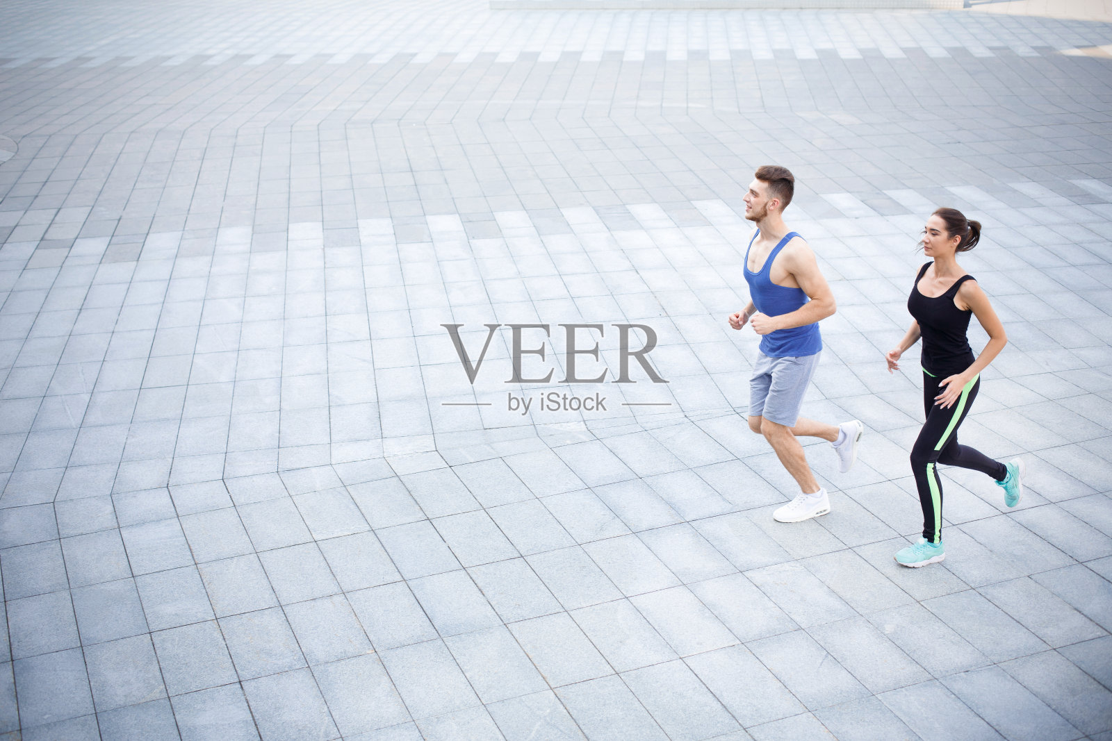 一男一女在市里的复印区跑着照片摄影图片