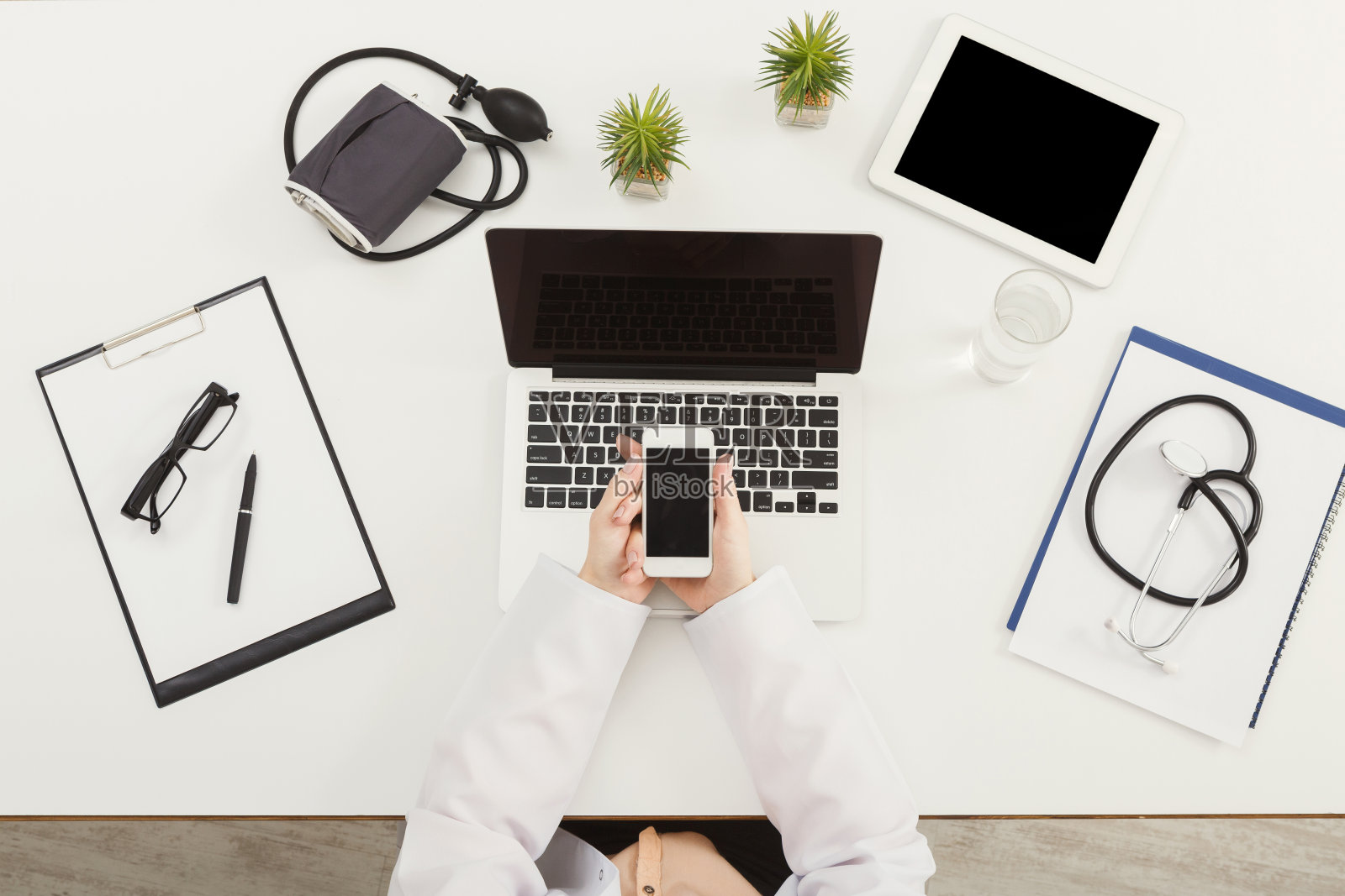 医生坐在办公桌前，俯视图照片摄影图片