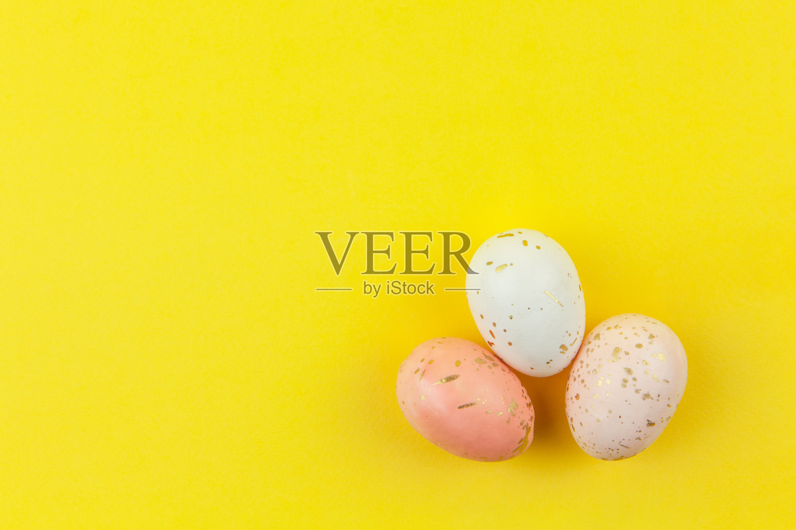 创造性地染色装饰鸡蛋，以柔和的颜色装饰金叶在黄色的背景，复制空间。复活节快乐，自己动手。平的。水平照片摄影图片