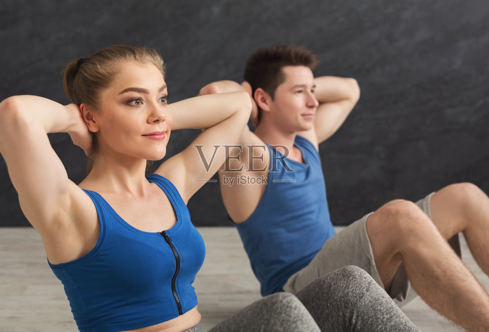 健身夫妻做仰卧起坐，特写照片摄影图片