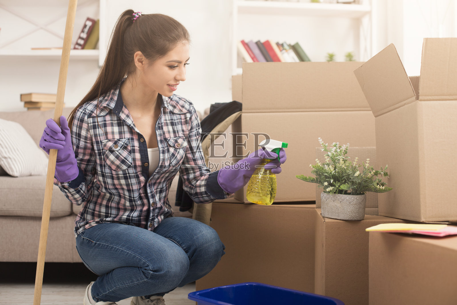 年轻女子在新房子里喷洒室内植物照片摄影图片