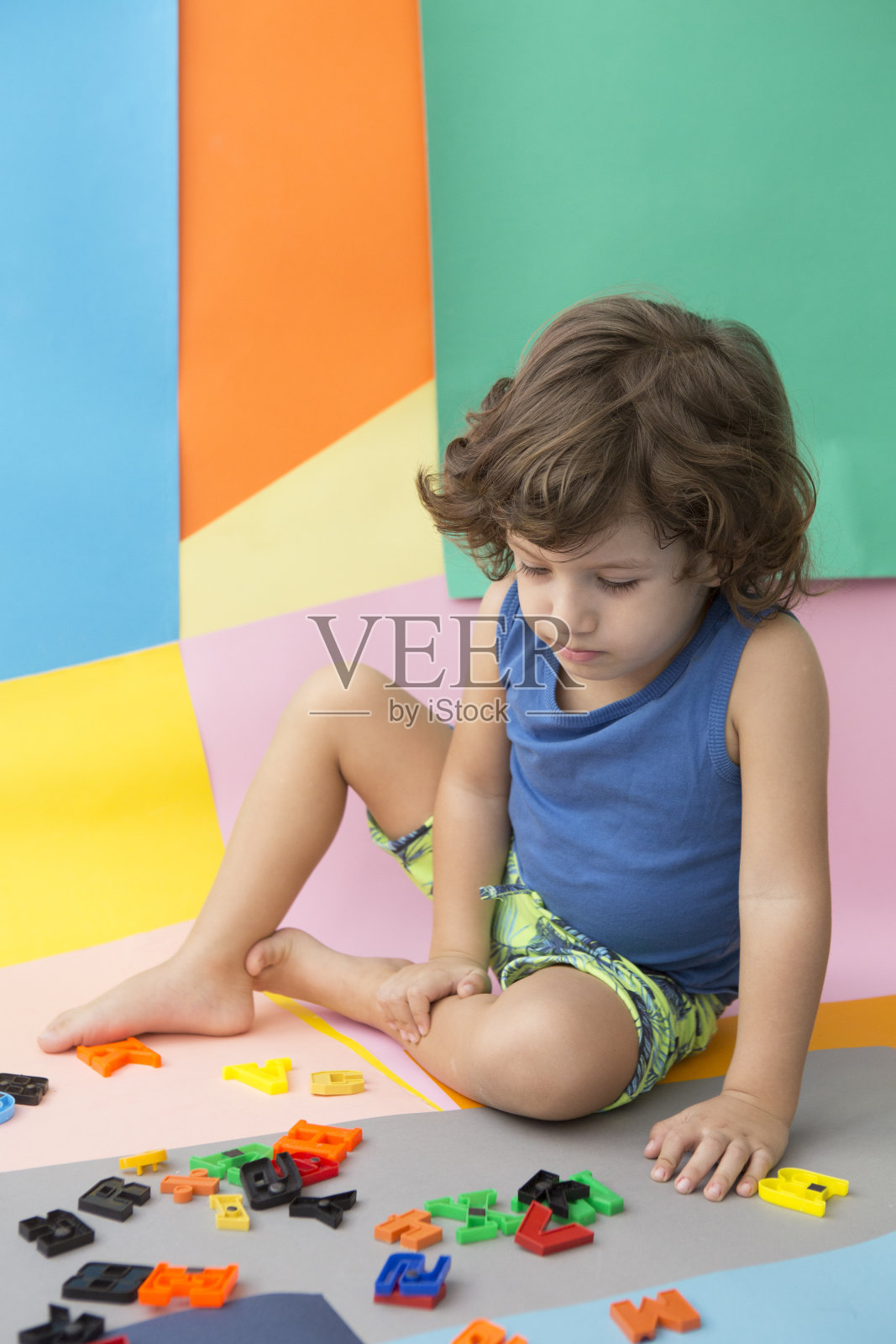 可爱的小男孩玩着五颜六色的字母照片摄影图片