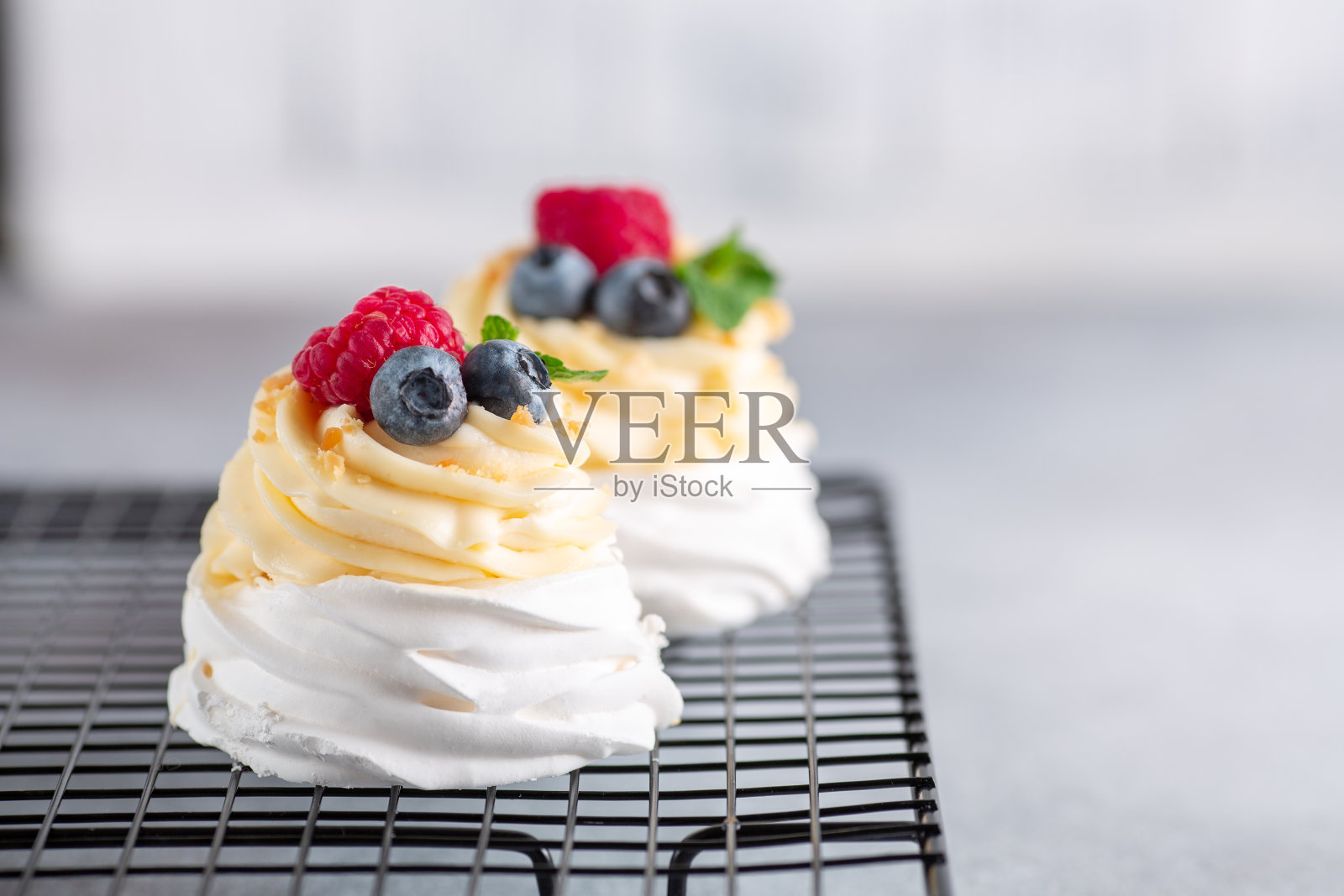 美味的巴甫洛娃蛋糕，鲜奶油和新鲜浆果放在冷却架上。有选择性的重点照片摄影图片