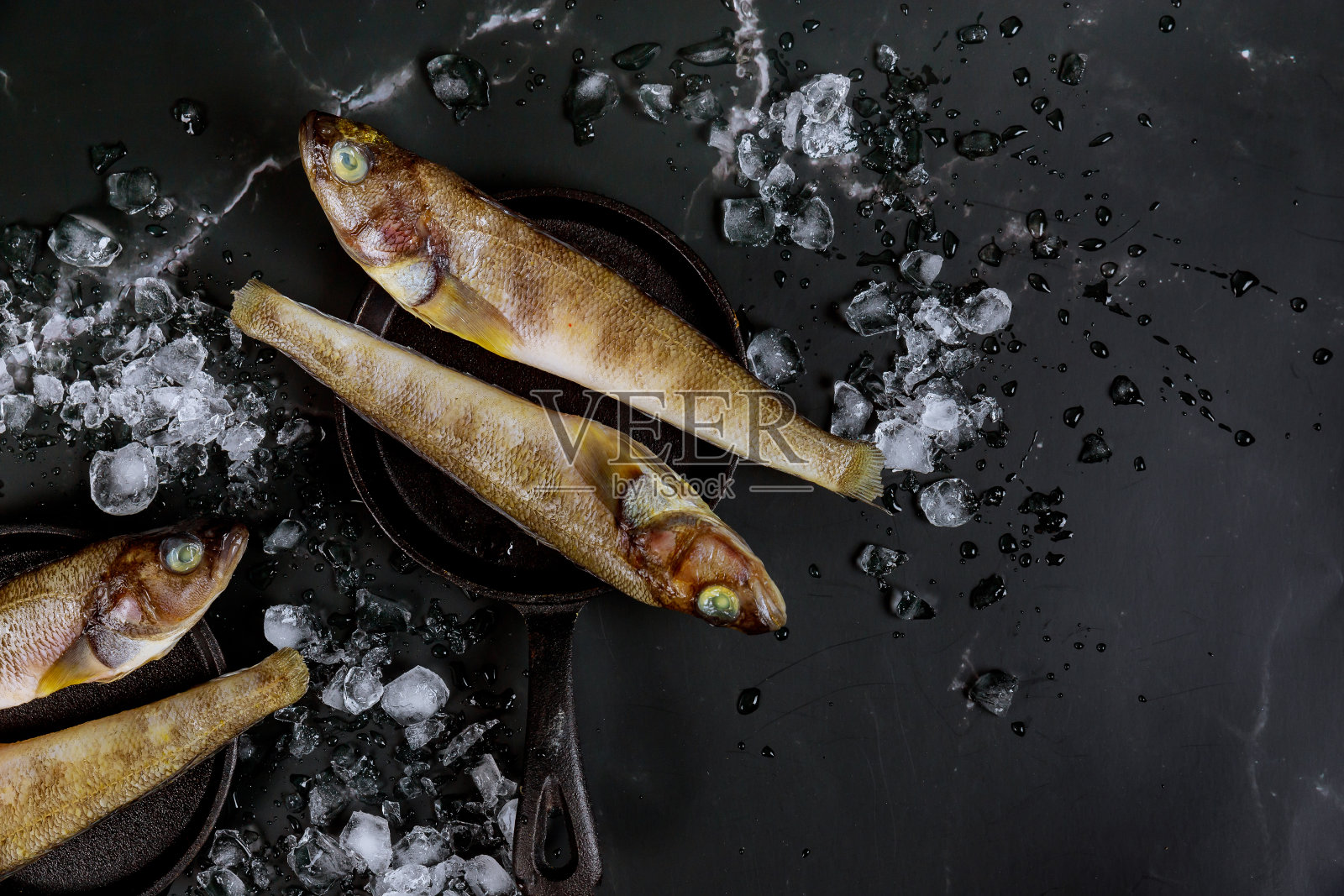 健康新鲜的生鱼在黑板上加冰。照片摄影图片