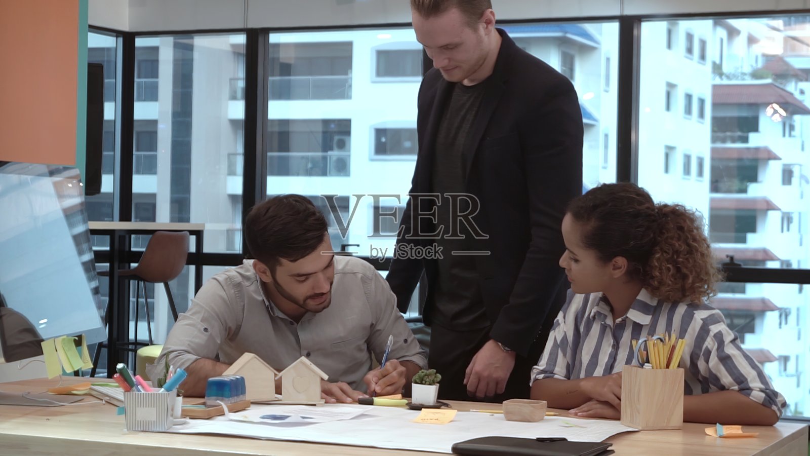 创意商务人士在办公桌旁交谈。照片摄影图片