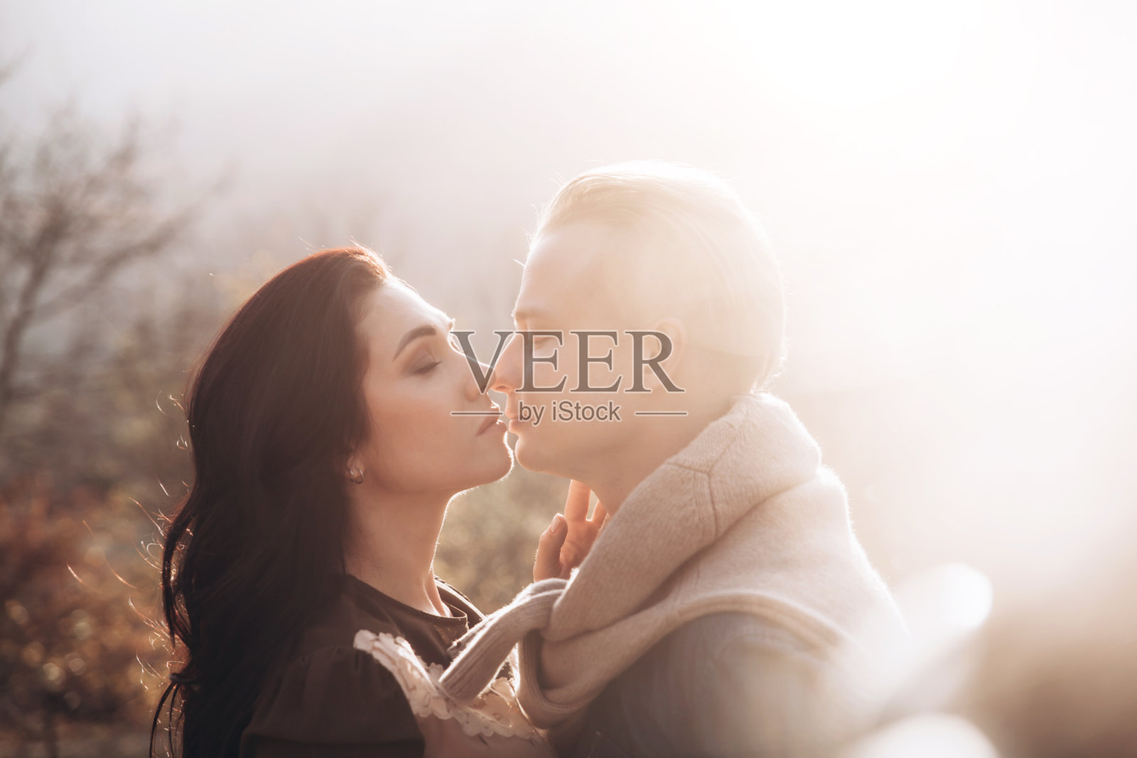 年轻夫妇在户外日落时分散步。照片摄影图片