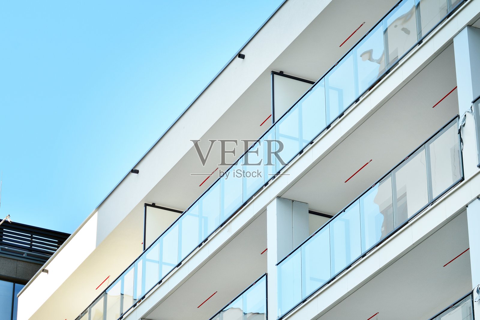 现代化的公寓大楼在一个晴朗的日子与蓝天。现代公寓楼的立面照片摄影图片