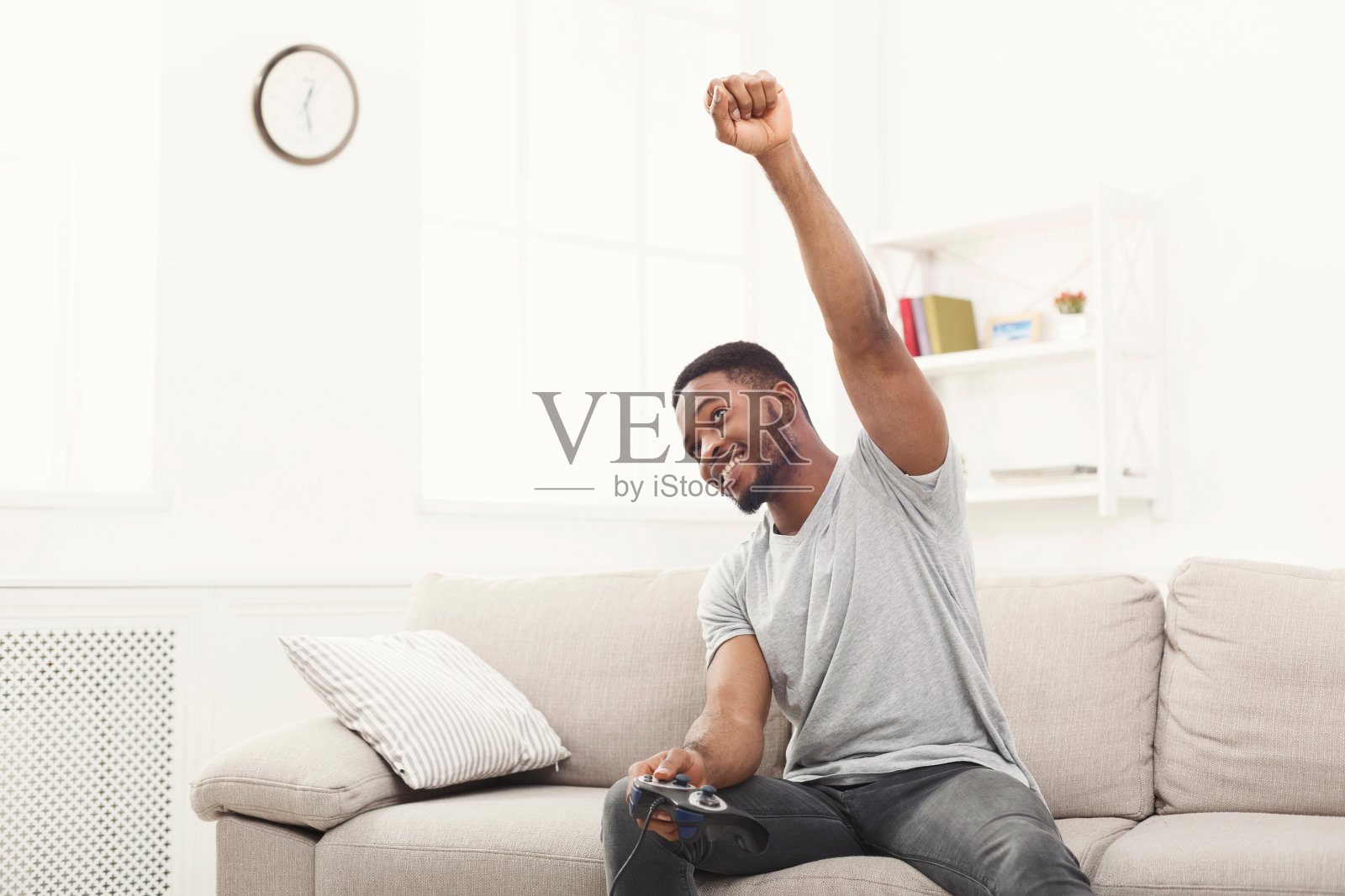 快乐的年轻人在家玩电子游戏和赢照片摄影图片