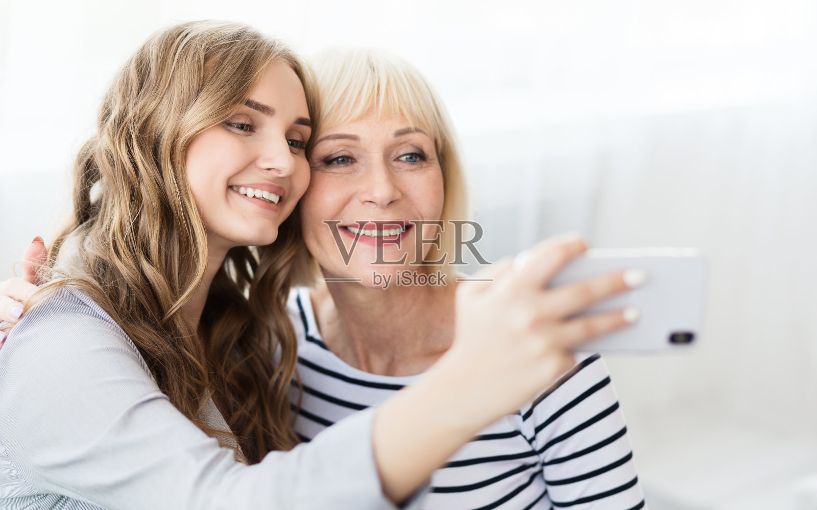 迷人的博主用智能手机和妈妈自拍照片摄影图片