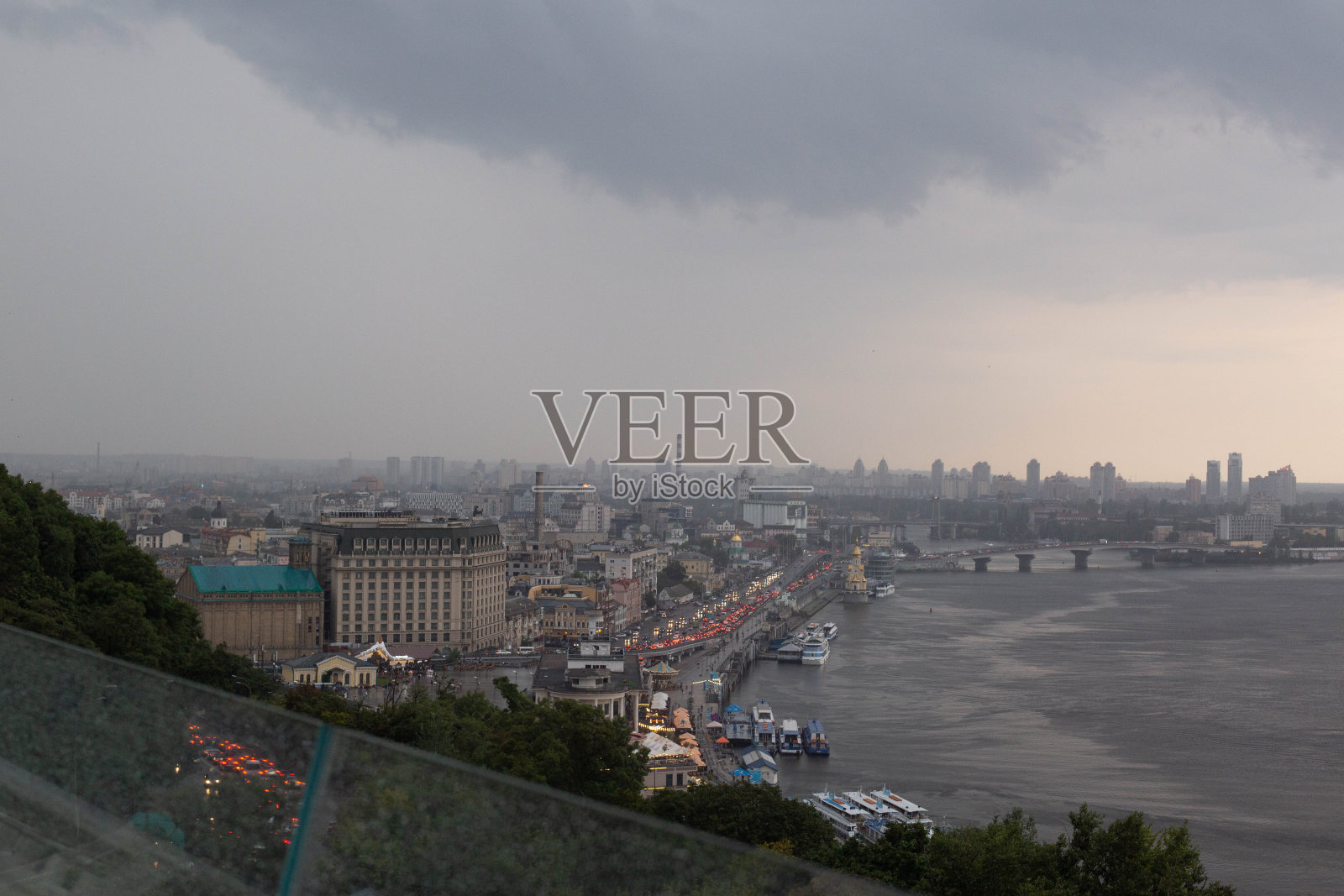 基辅傍晚城市和第聂伯河的玻璃人行桥背景美景，雷暴和飓风即将来临照片摄影图片