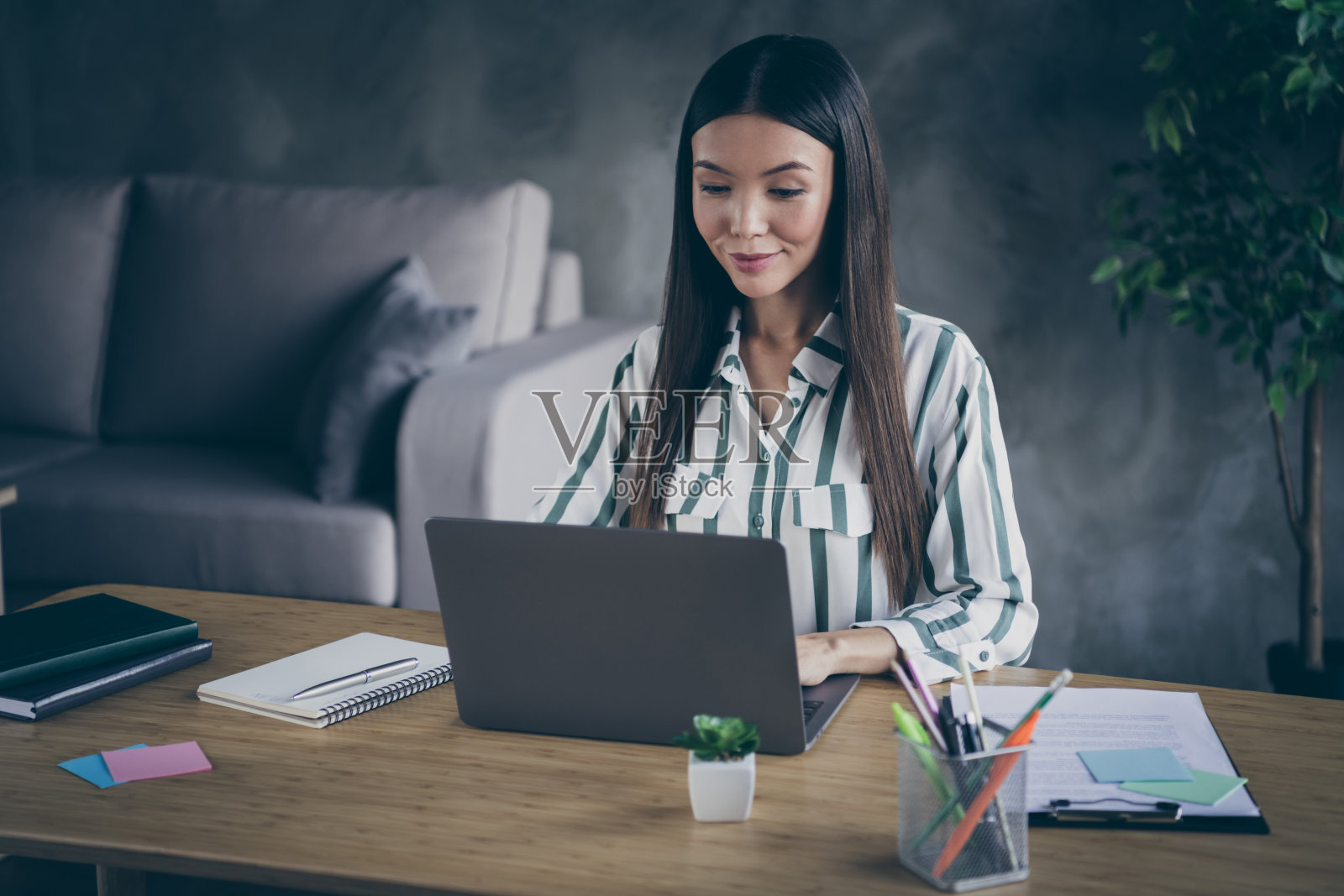 照片愉快的商务女士高兴地看到公司收入增加了笔记本和笔躺在笔记本旁边照片摄影图片