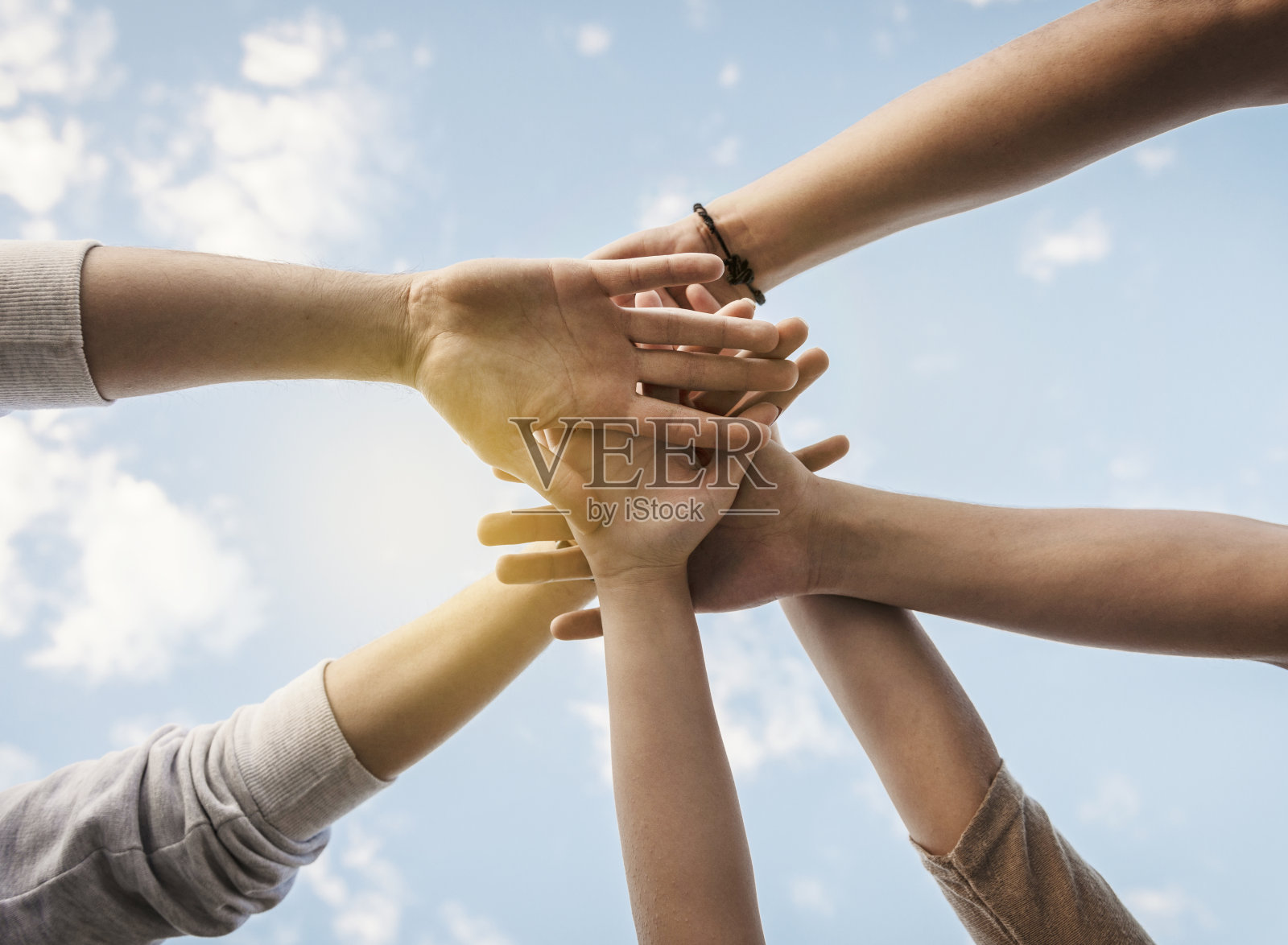 一群人双手搭在天空上照片摄影图片