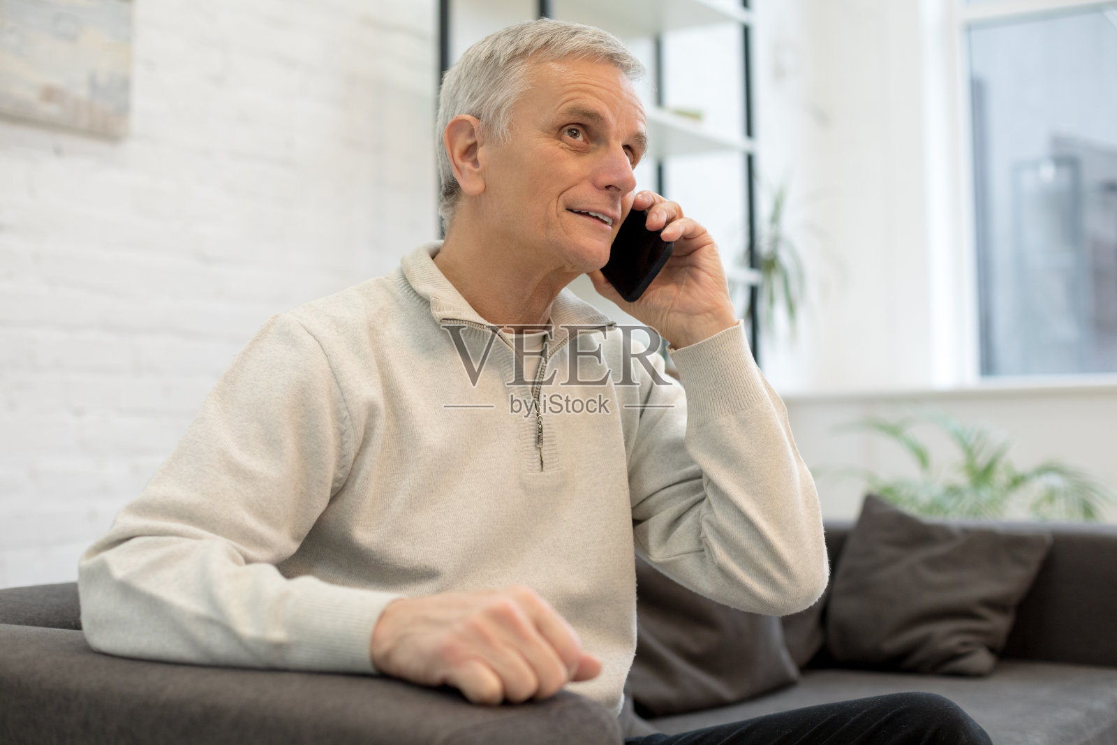 微笑的老人在家里用手机照片摄影图片