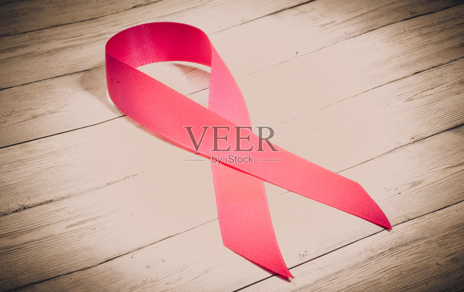 木制背景上的粉色丝带是乳腺癌的象征，是与癌症抗争的标志照片摄影图片