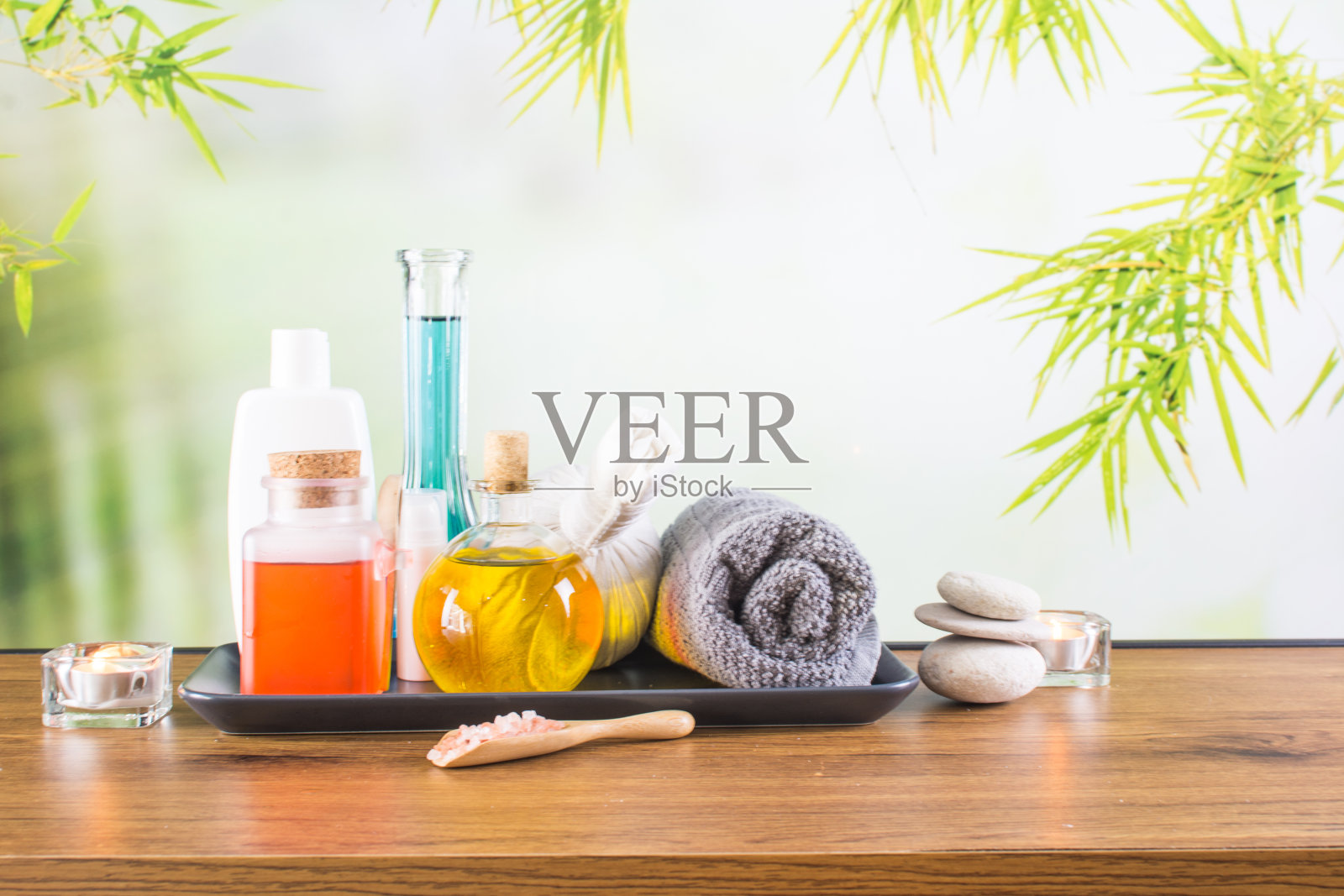 近距离的美容和时尚概念与水疗设置的健康中心。美丽的spa美容产品概念，按摩和芳香疗法油在竹林轻和散照片摄影图片