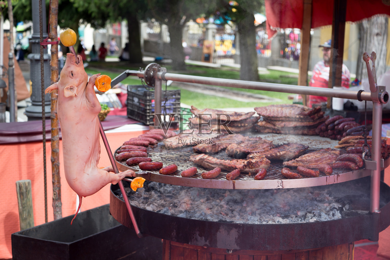 小猪、排骨和烤猪肉香肠放在一个巨大的圆形烤架上照片摄影图片