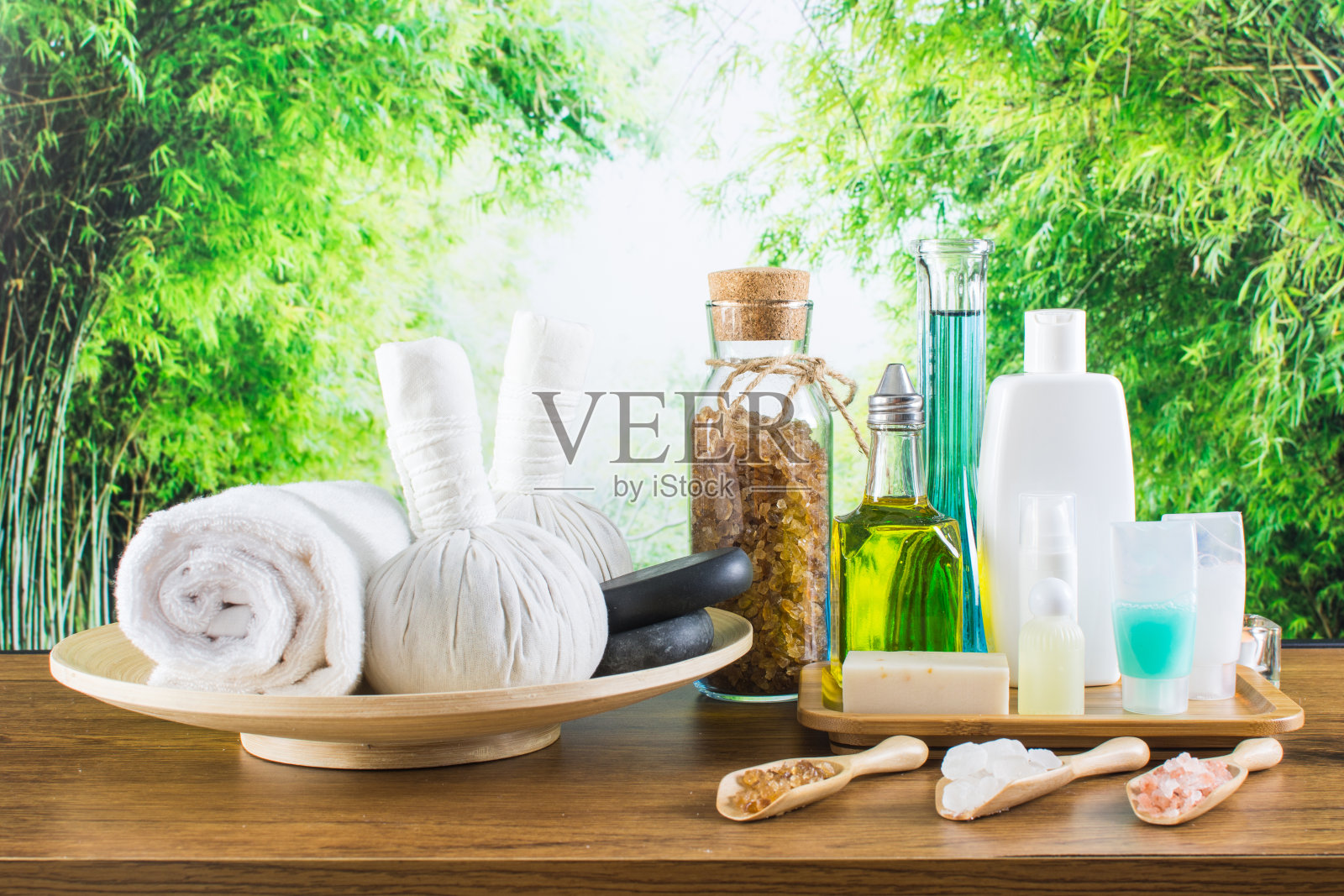 近距离的美容和时尚概念与水疗设置的健康中心。美丽的spa美容产品概念，按摩和芳香疗法油在竹林轻和散照片摄影图片