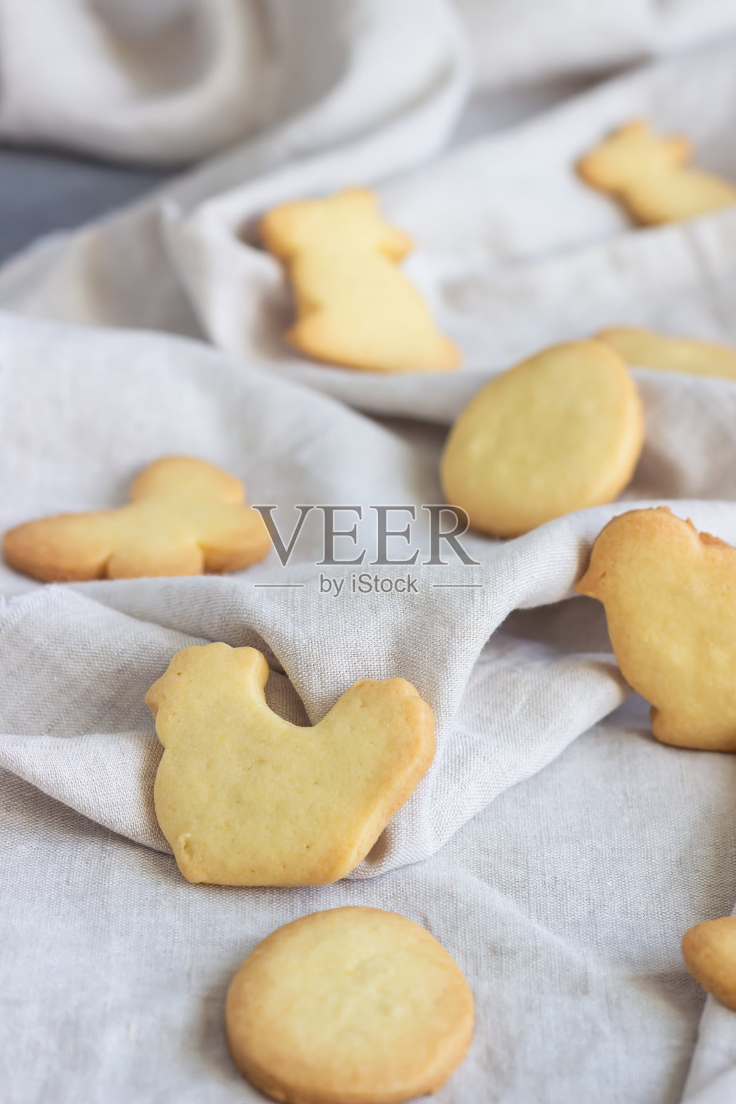 灰色的亚麻餐巾上放着复活节饼干。自制黄油和糖饼干。照片摄影图片