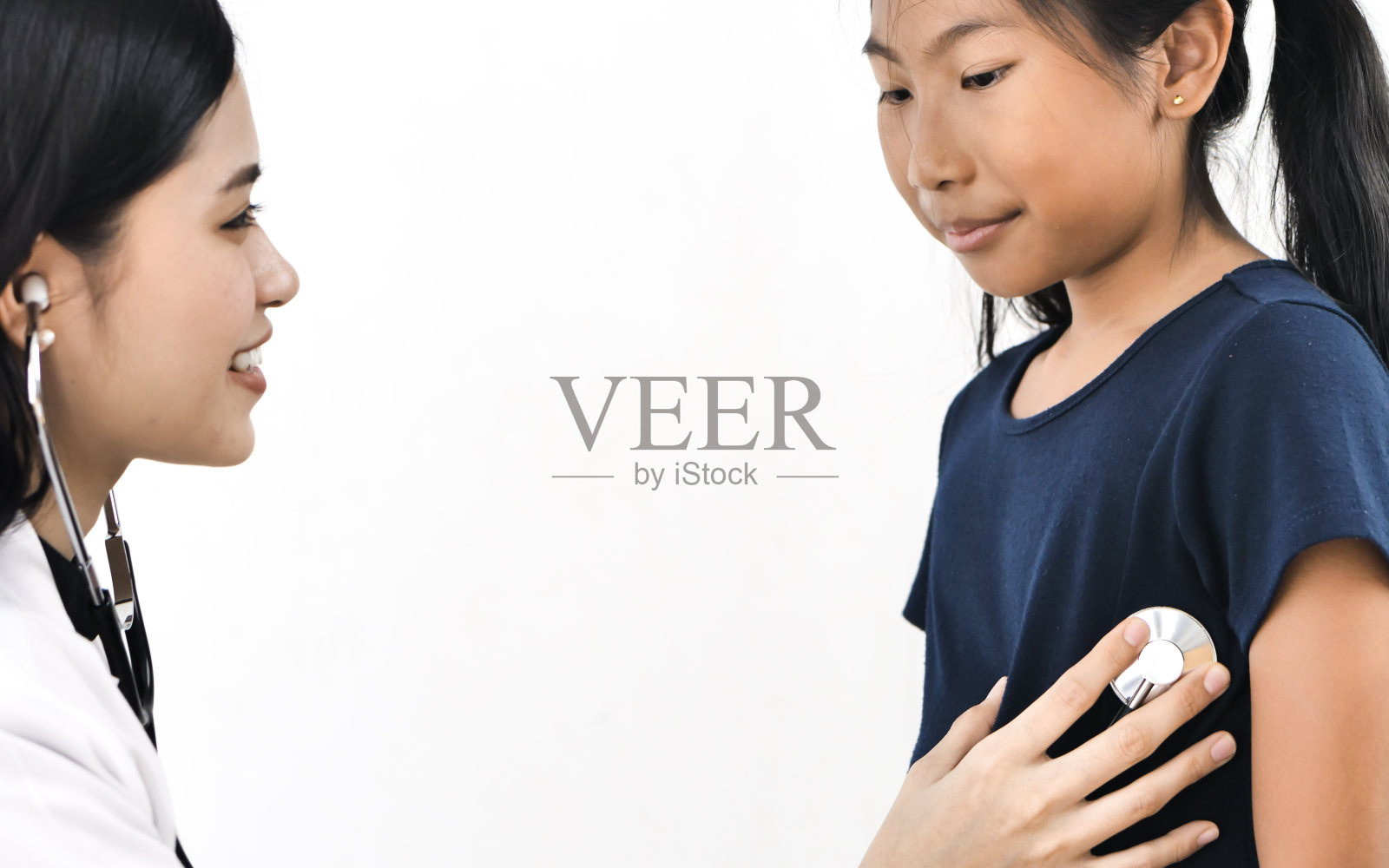 医生用听诊器检查一个小女孩照片摄影图片