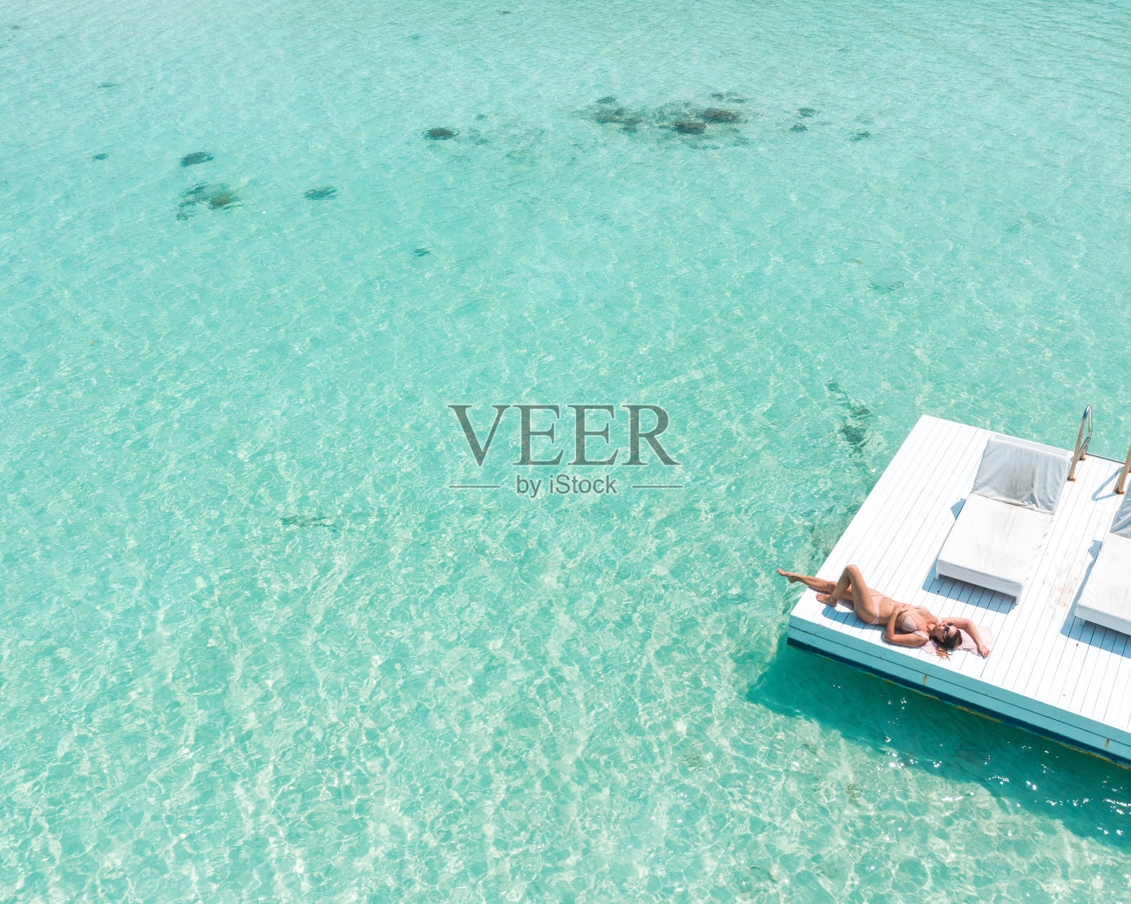 女人在海上漂浮平台上放松照片摄影图片