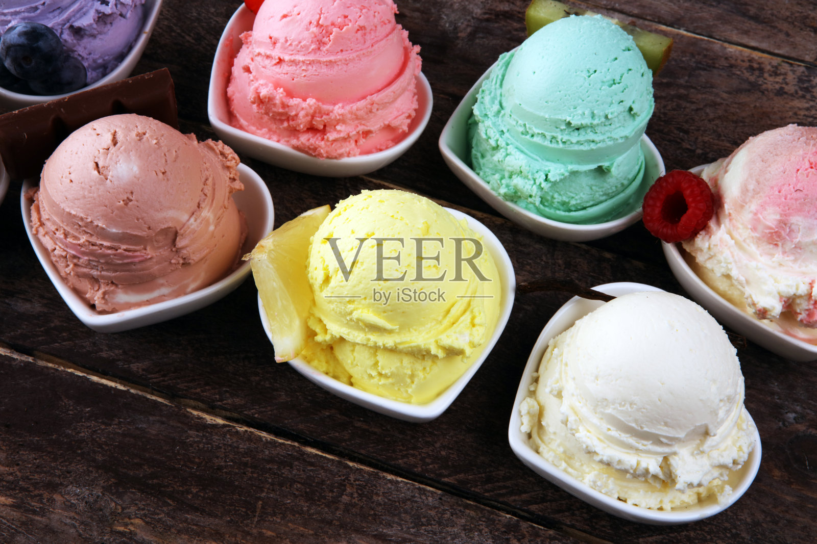 各种口味的冰淇淋搭配新鲜的蓝莓，草莓，猕猴桃，柠檬，香草。夏天和甜冰激淋照片摄影图片