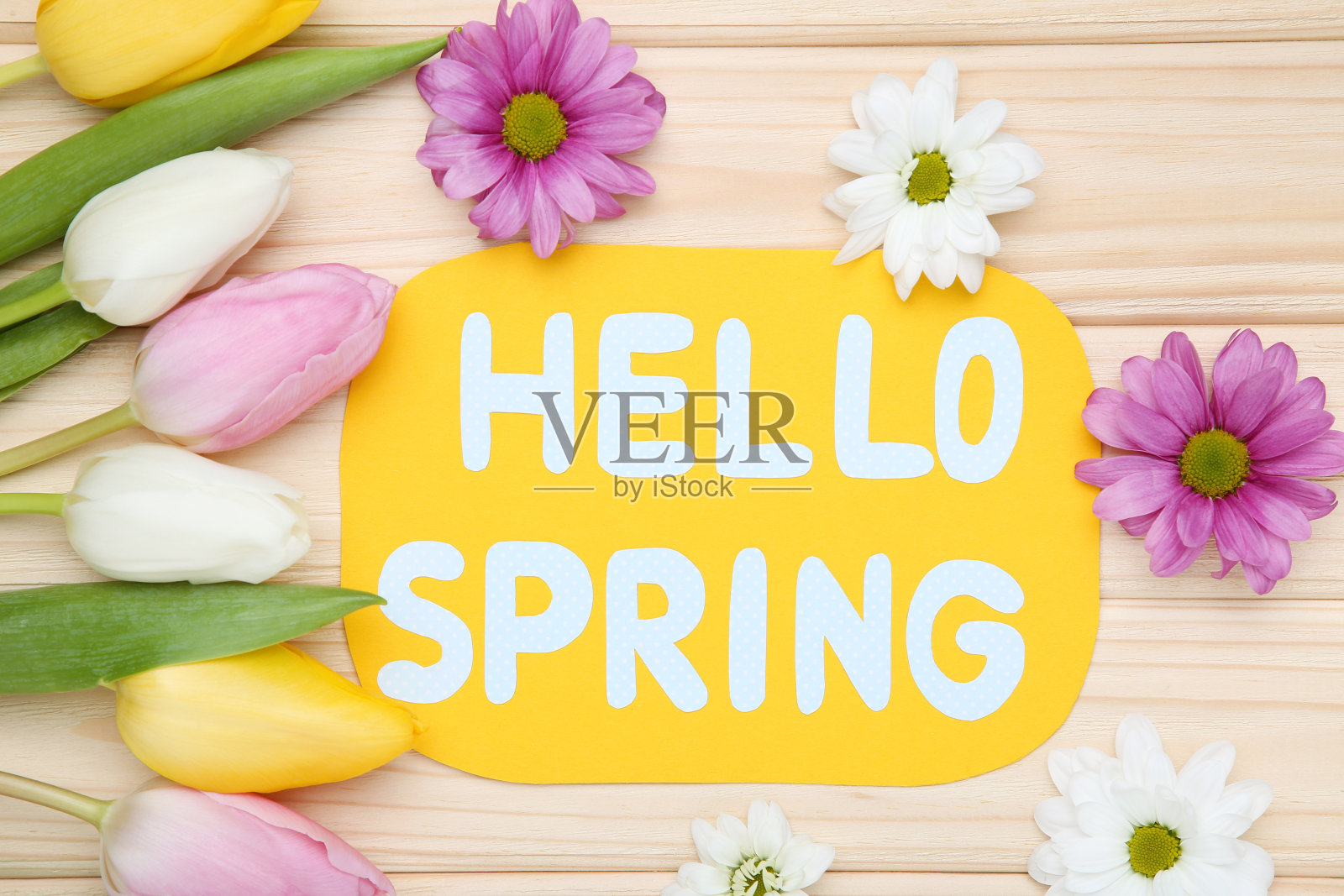 棕色木桌上放着郁金香、菊花和文字“春天好”照片摄影图片