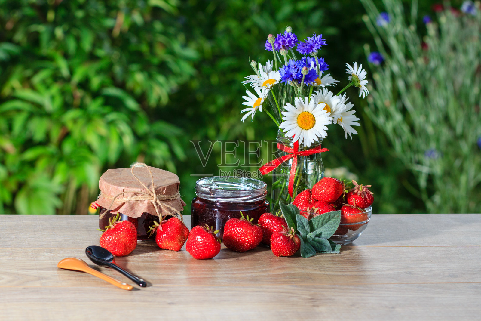 传统的自制草莓酱和一束鲜花照片摄影图片