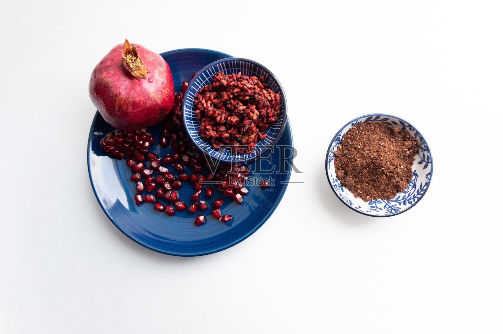 俯视图在地面石榴种子香料碗在白色的背景与石榴果实和浆果照片摄影图片
