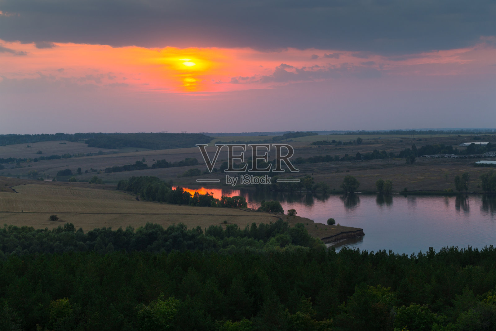 日落背景下的河流、田野和森林的全景照片摄影图片