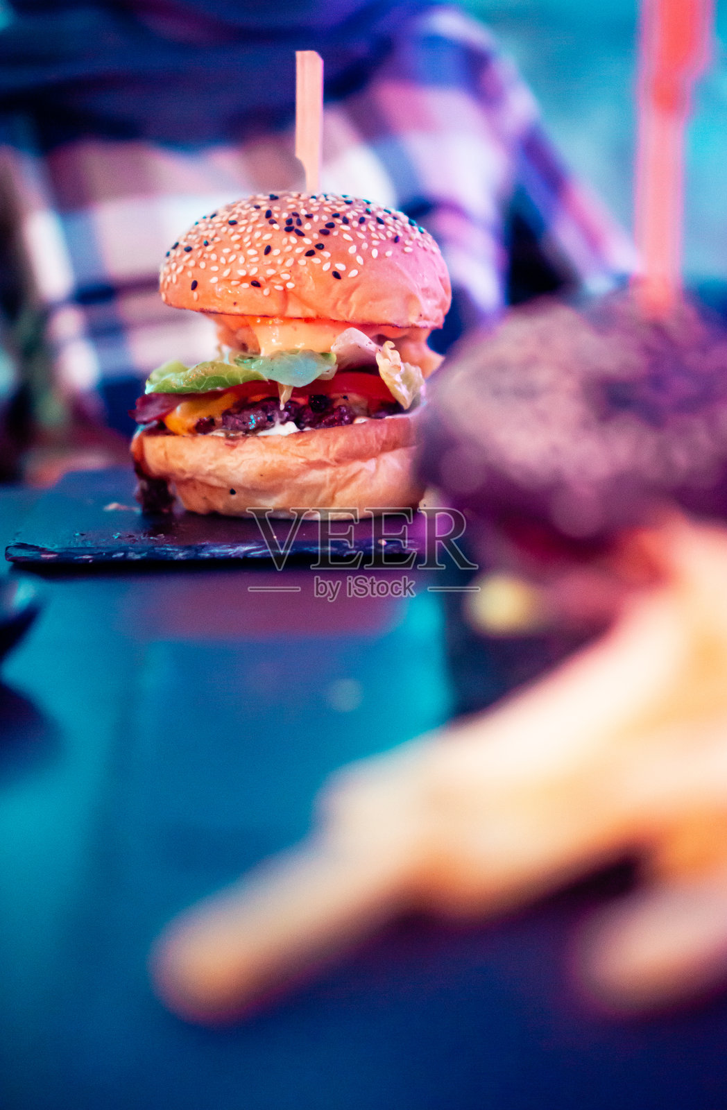 新鲜牛肉汉堡与黑色汉堡在彩色的光照片摄影图片