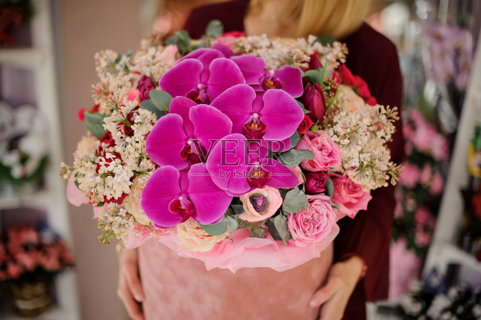 一个女人站在盒子里的巨大花束的特写照片摄影图片