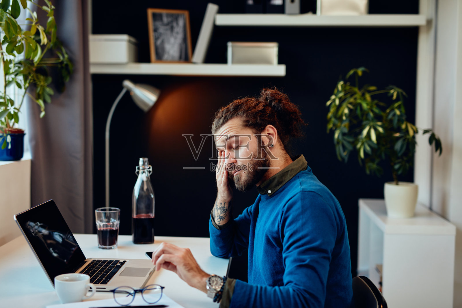 疲惫的胡须男士坐在办公室揉眼睛照片摄影图片