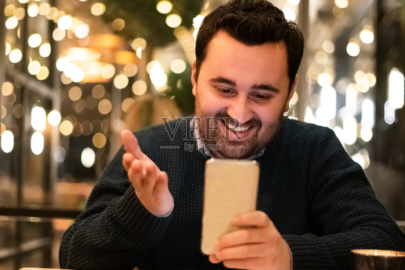 一个年轻人坐在咖啡馆里打视频电话照片摄影图片