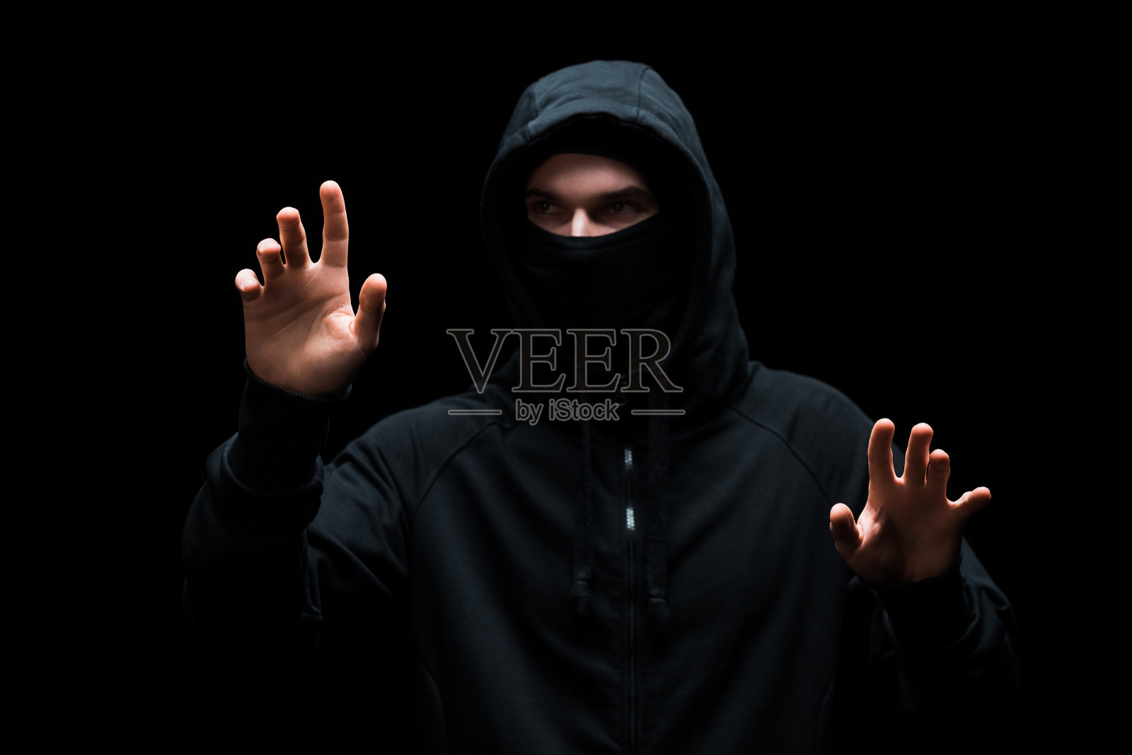 兜帽的匿名黑客在黑色屏幕上做孤立手势照片摄影图片