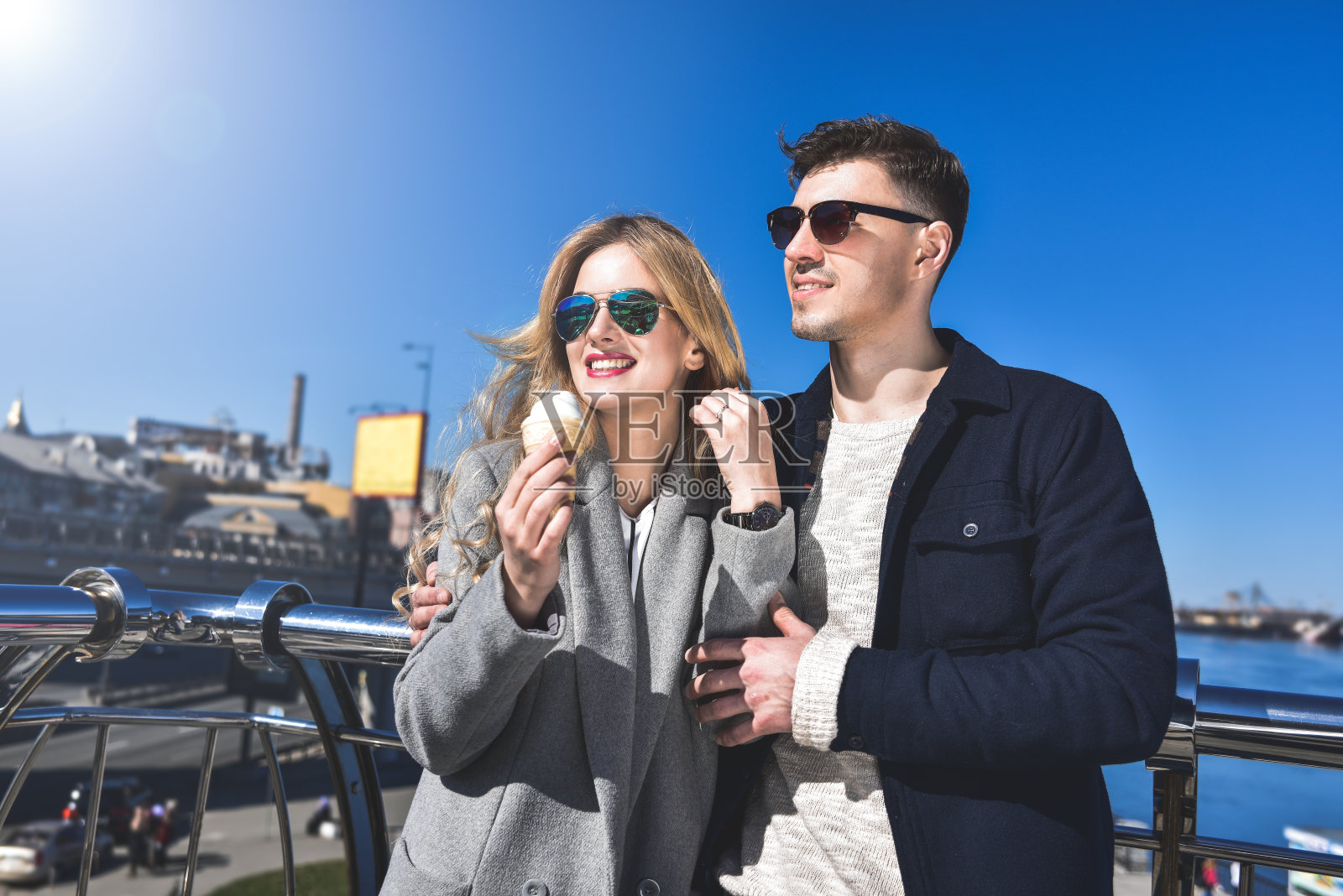 一对戴着太阳镜的幸福浪漫的白人夫妇。有趣的女孩吃了冰淇淋照片摄影图片