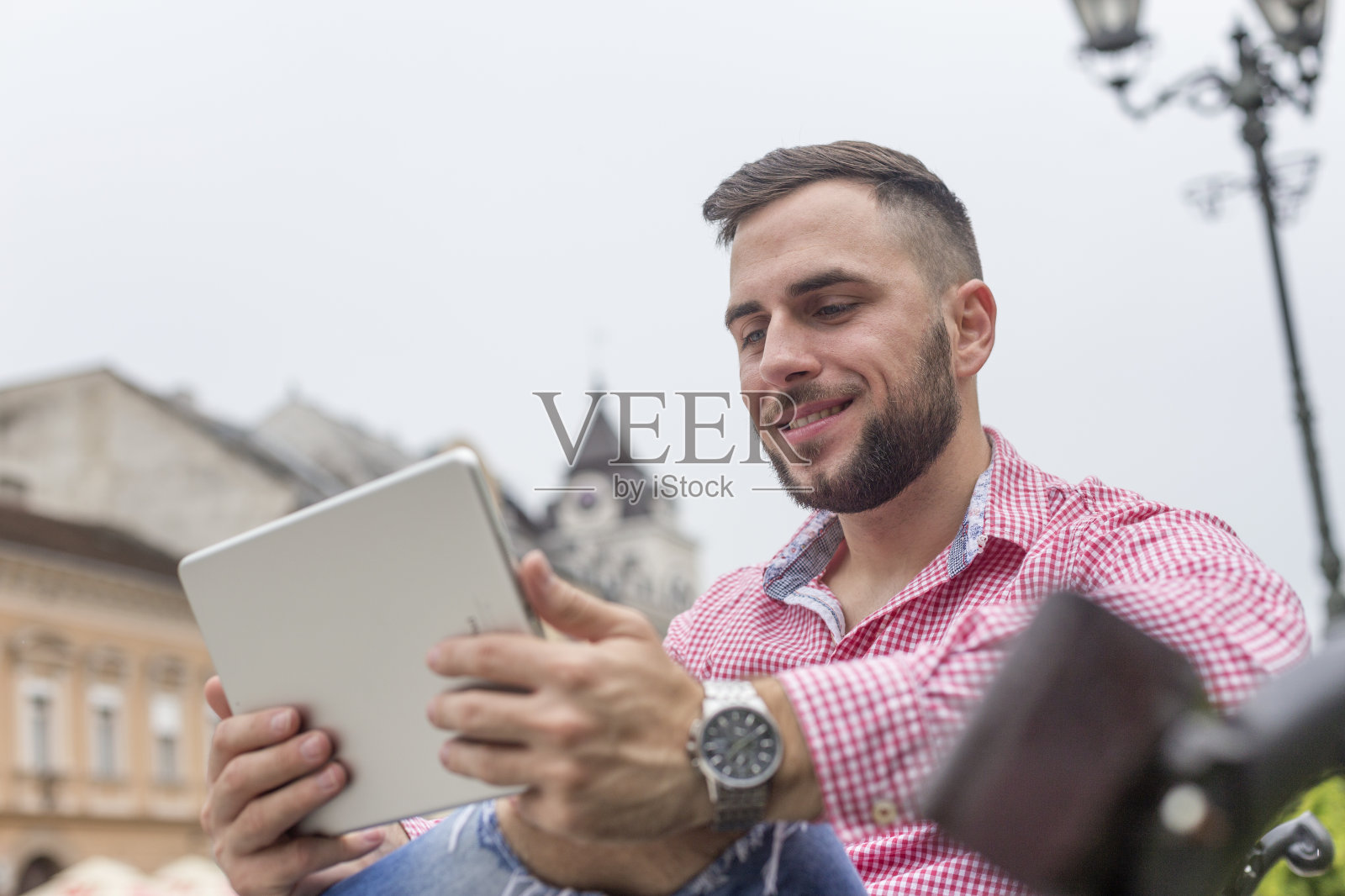 一名男子戴着手表，手里拿着平板电脑照片摄影图片