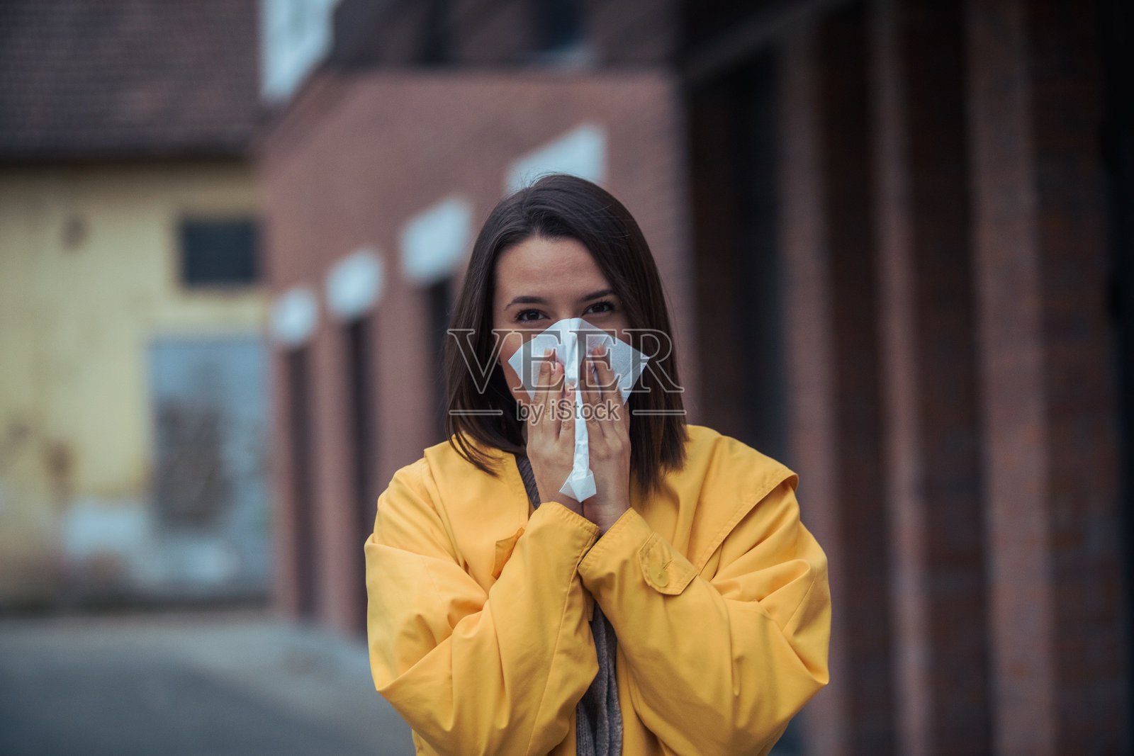 生病的年轻女子在擤鼻涕照片摄影图片