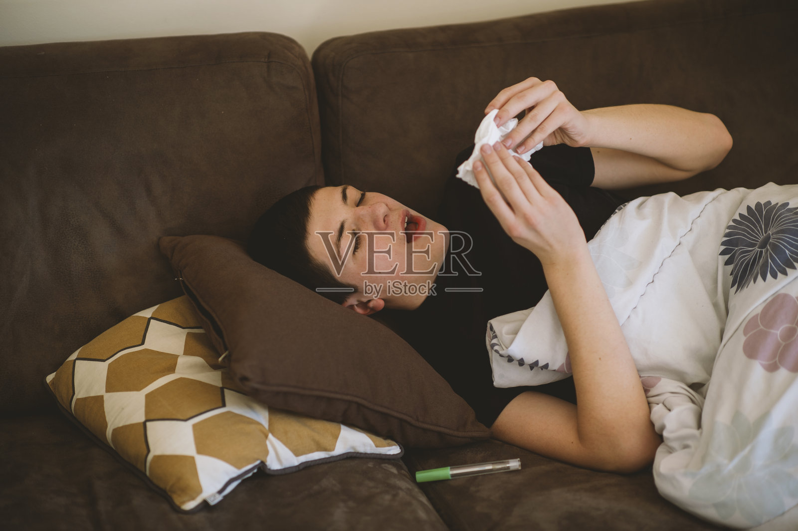 生病的少年躺在床上擤鼻涕照片摄影图片