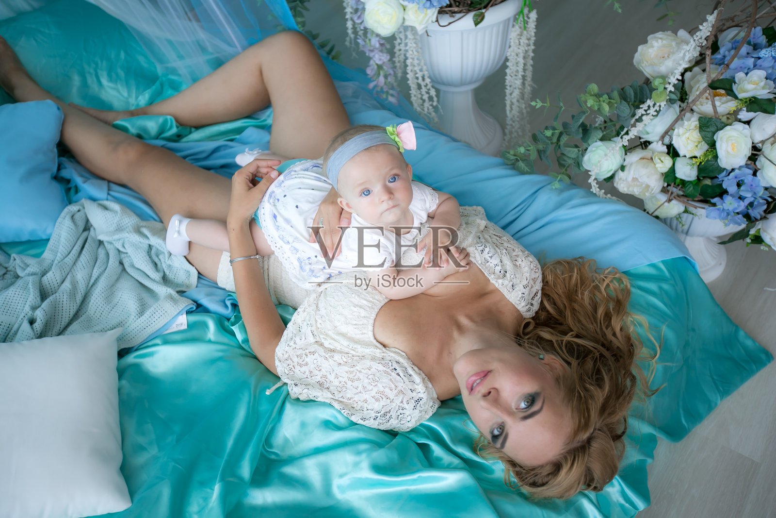 抱着孩子的年轻母亲会给予孩子温柔、拥抱和亲吻照片摄影图片