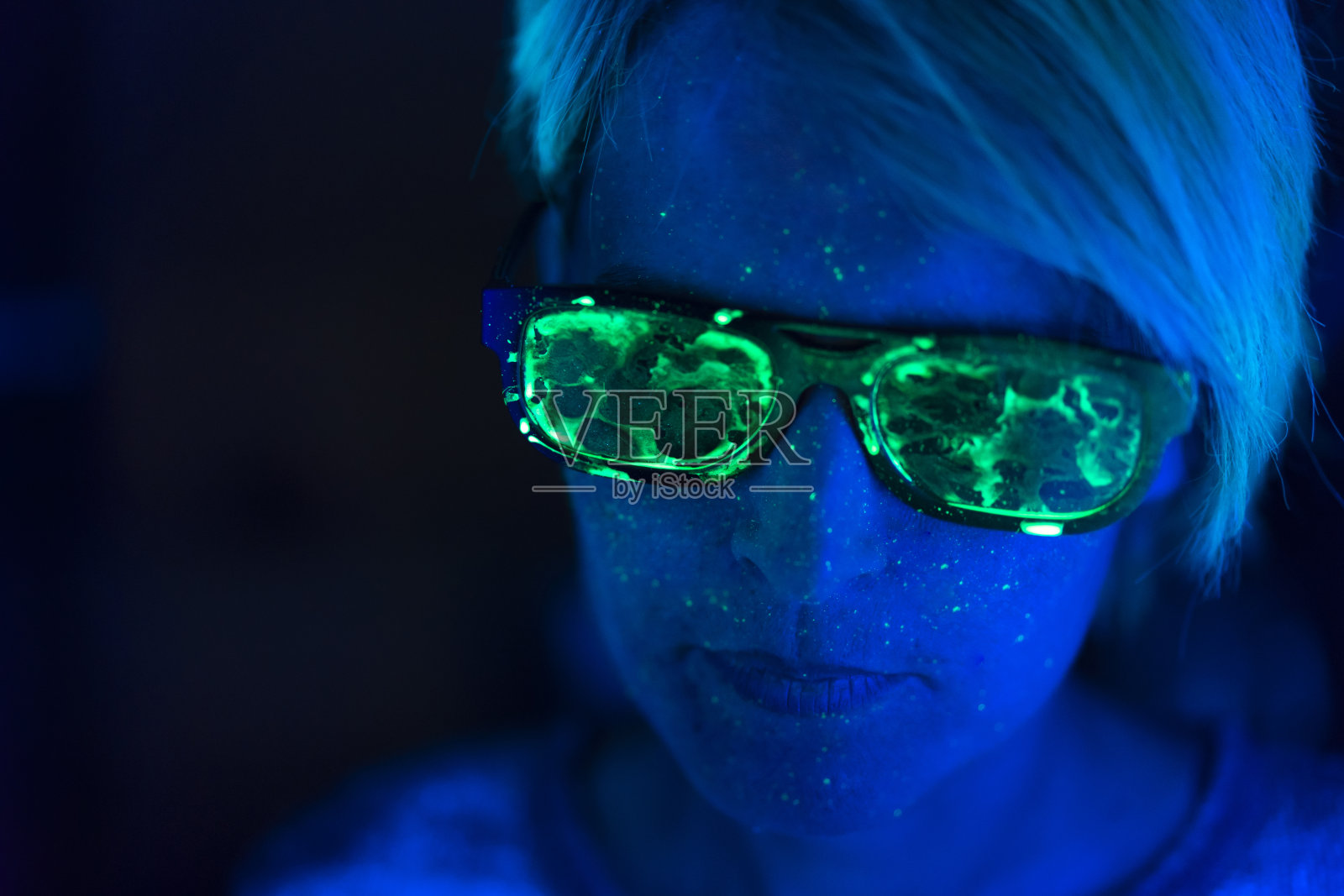 荧光色太阳镜女人的特写，蓝色光芒照片摄影图片
