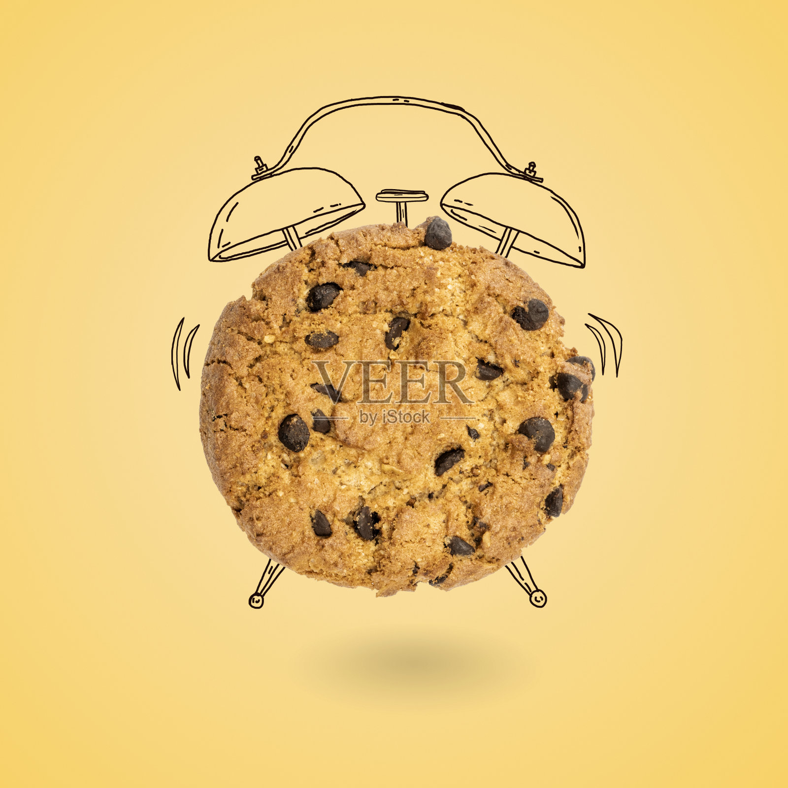 在黄色的背景上，一个装有巧克力屑的闹钟形状的甜饼乾悬浮在空中照片摄影图片