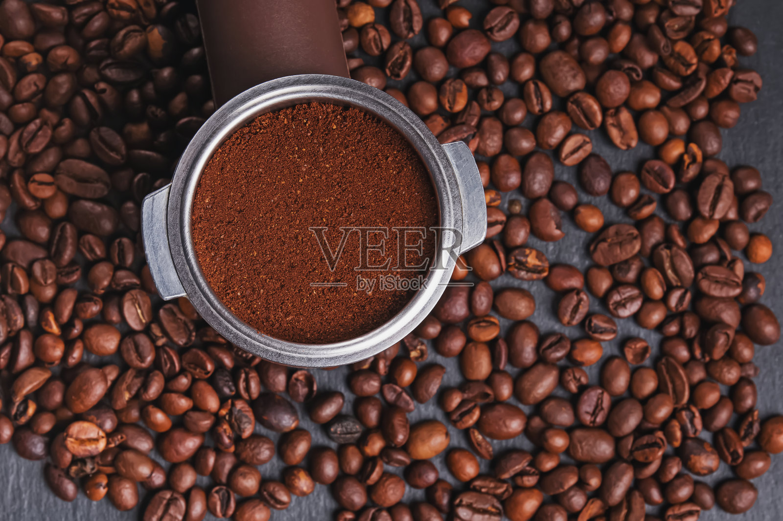 黑色背景上的咖啡滤杯和散落的烘焙咖啡豆照片摄影图片