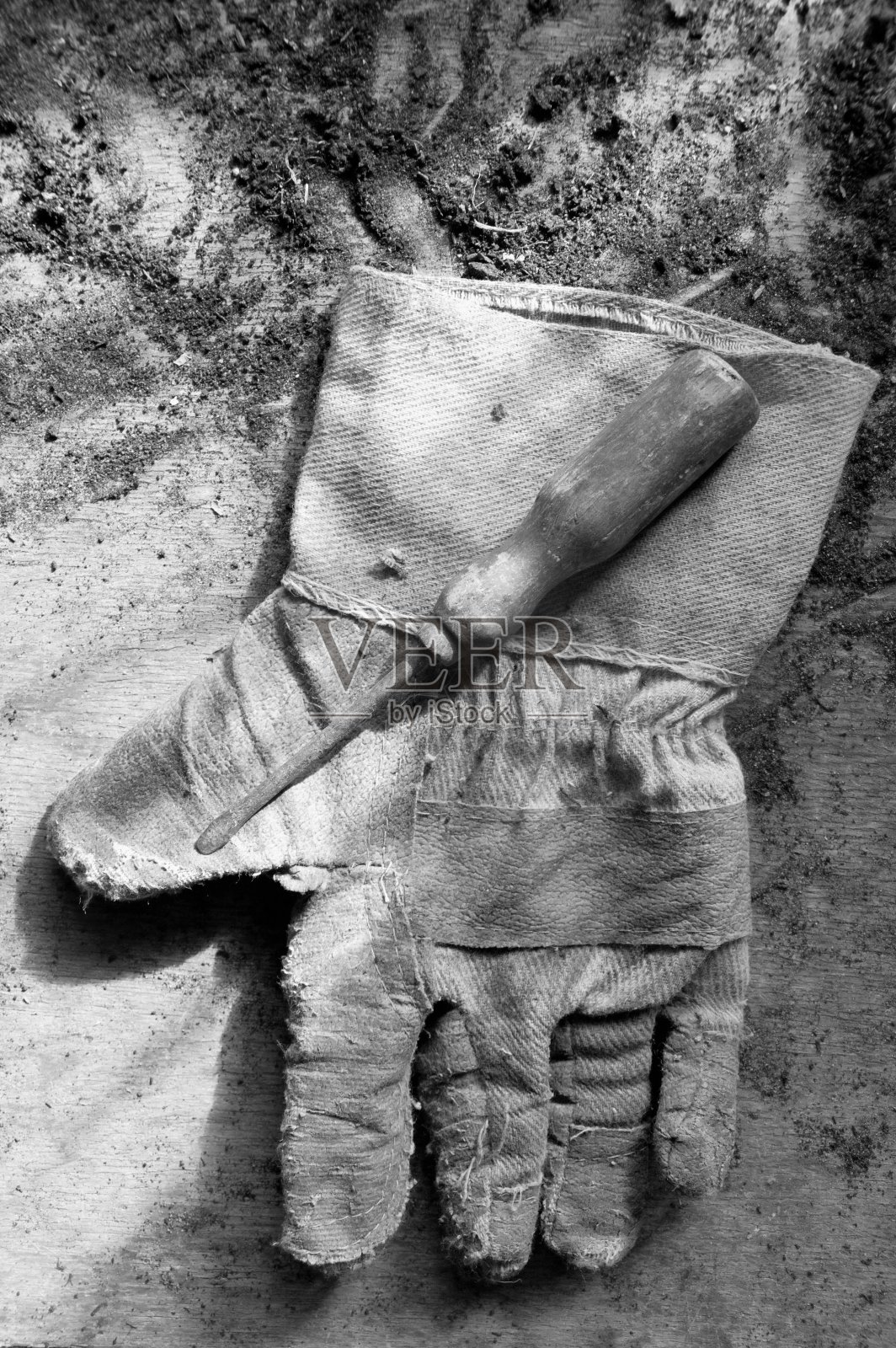 脏桌子上的一只旧手套上的螺丝刀照片摄影图片